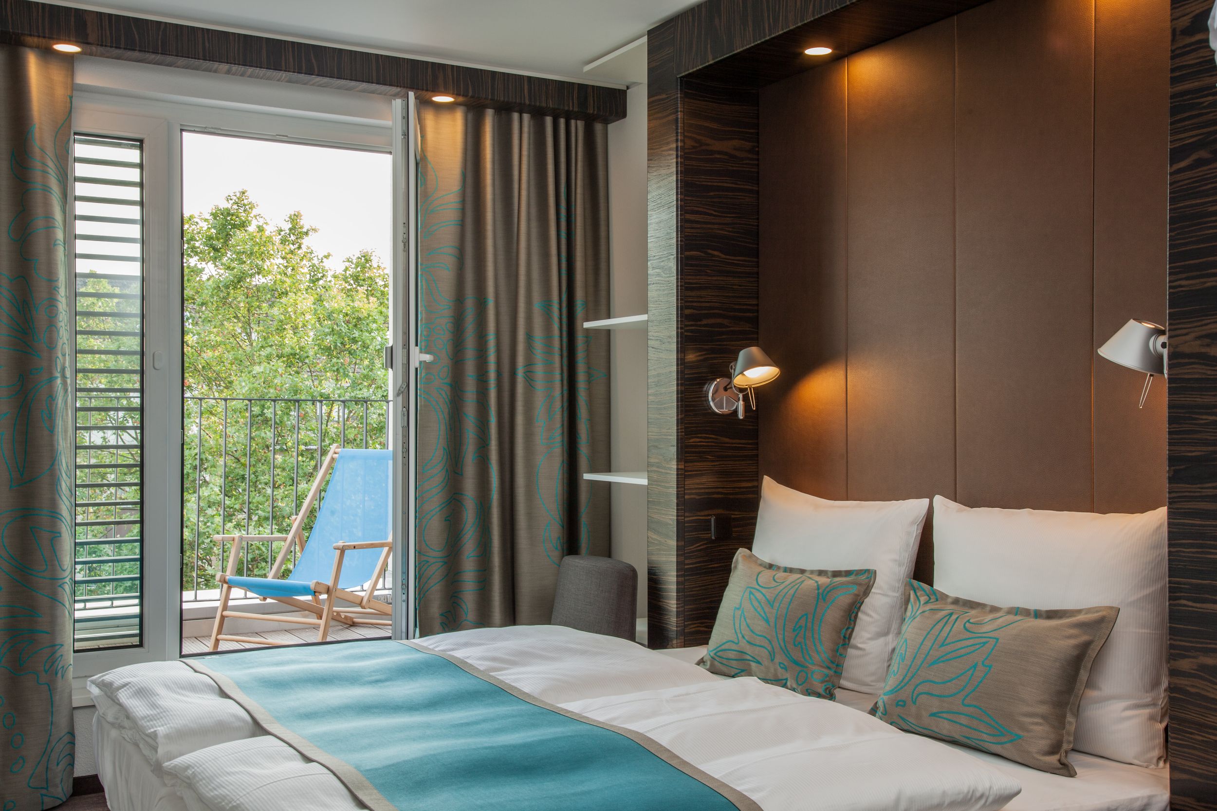 Hotel Düsseldorf Hauptbahnhof Motel One Balkonzimmer mit Doppelbett und Liegestuhl auf dem Balkon