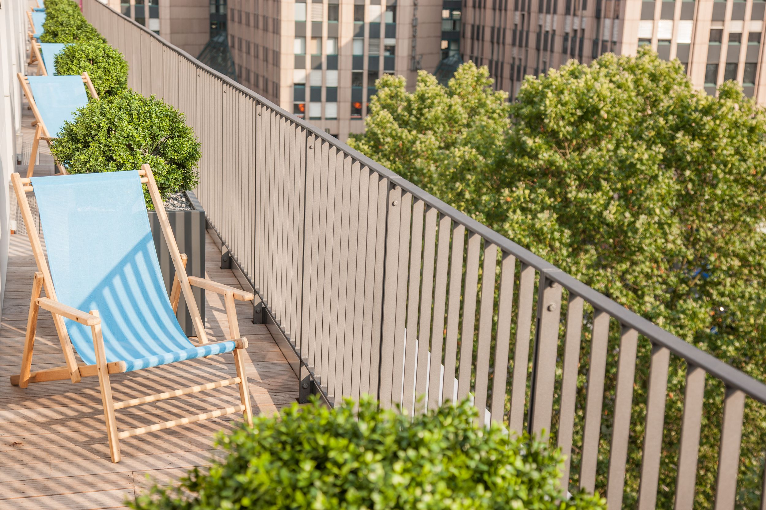 Hotel Düsseldorf Hauptbahnhof Motel One Balkone mit Liegestühlen, durch grüne Pflanzen voneinander abgetrennt
