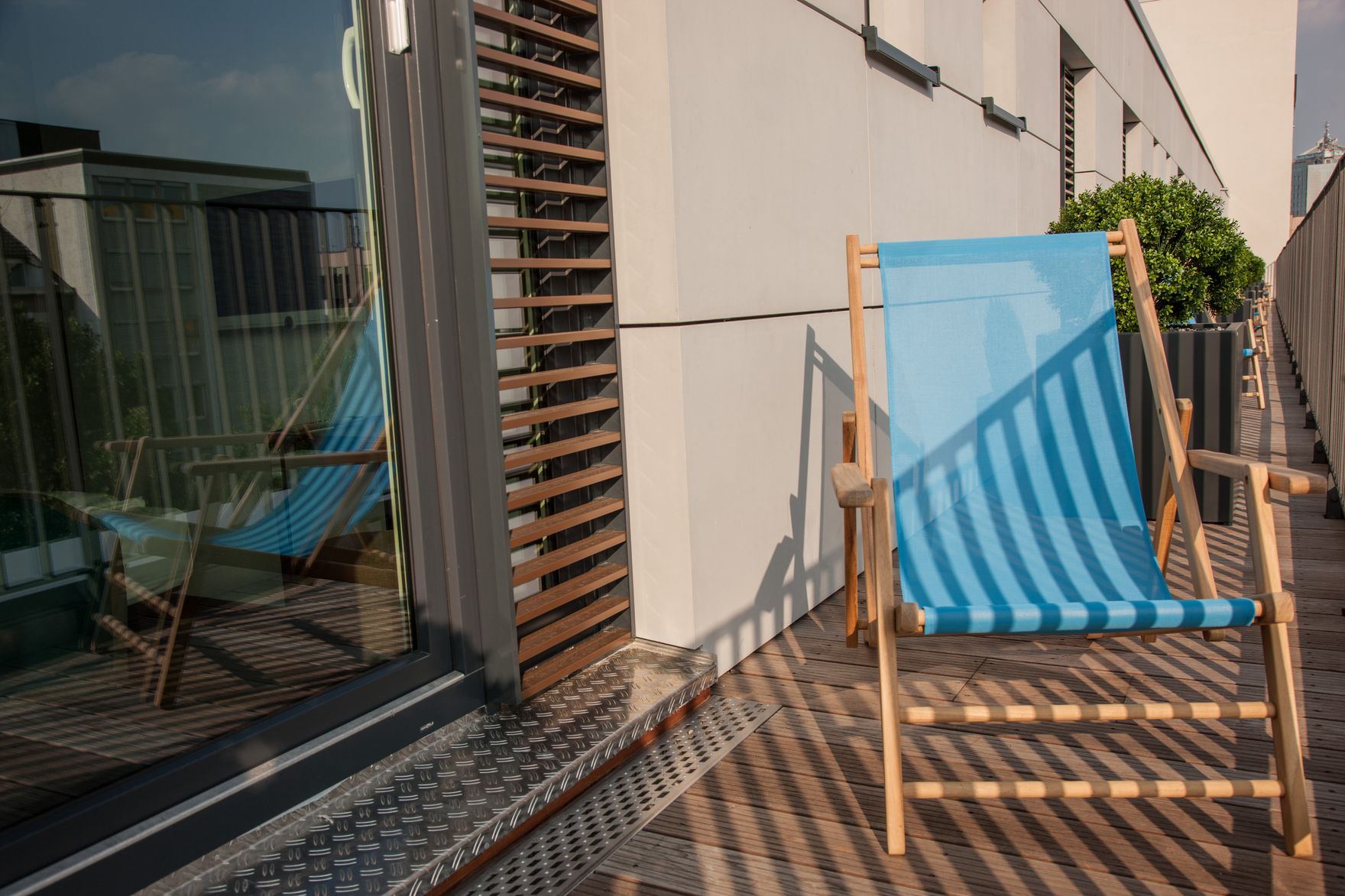 Hotel Düsseldorf Hauptbahnhof Motel One Blick auf einen Liegestuhl, der auf einem Balkon steht, im Hintergrund weitere Liegestühle