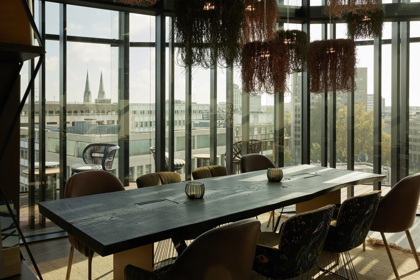 Designhotel Düsseldorf KöBogen The Cloud One langer Tisch mit acht Stühlen in hellem Raum mit bodentiefer Fensterfront