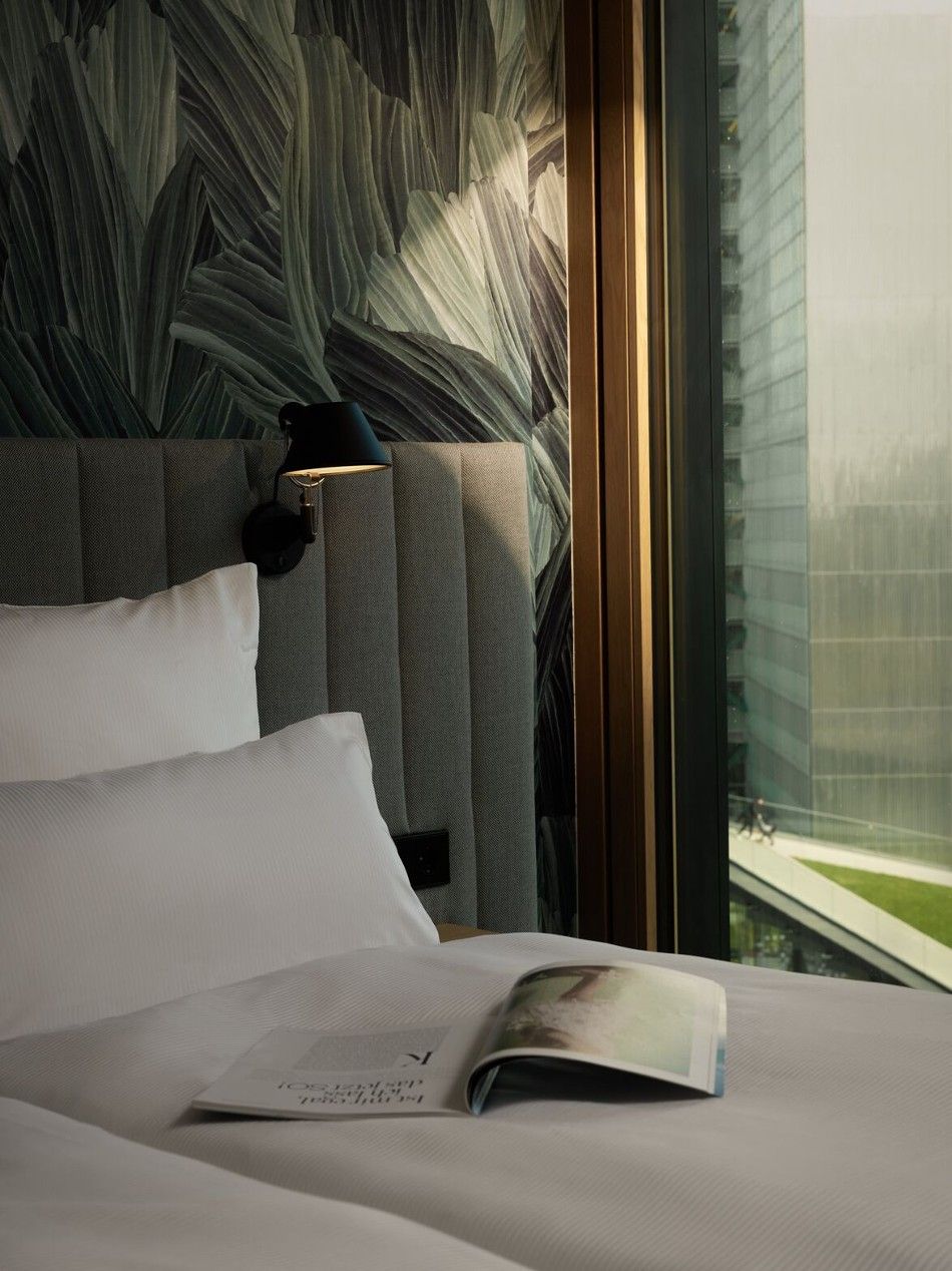 Designhotel Düsseldorf KöBogen The Cloud One Zimmer mit einer aufgeschlagenen Zeitschrift auf dem Bett