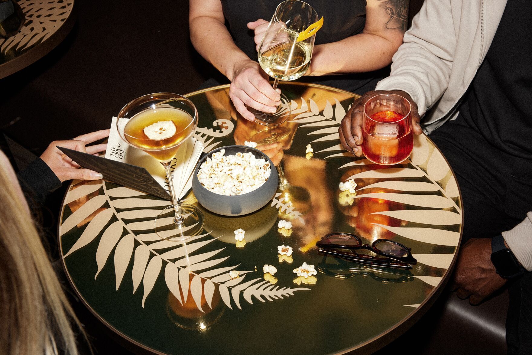 Hotel Düsseldorf KöBogen The Cloud One Personen an einem Tisch mit Drinks und Popcorn