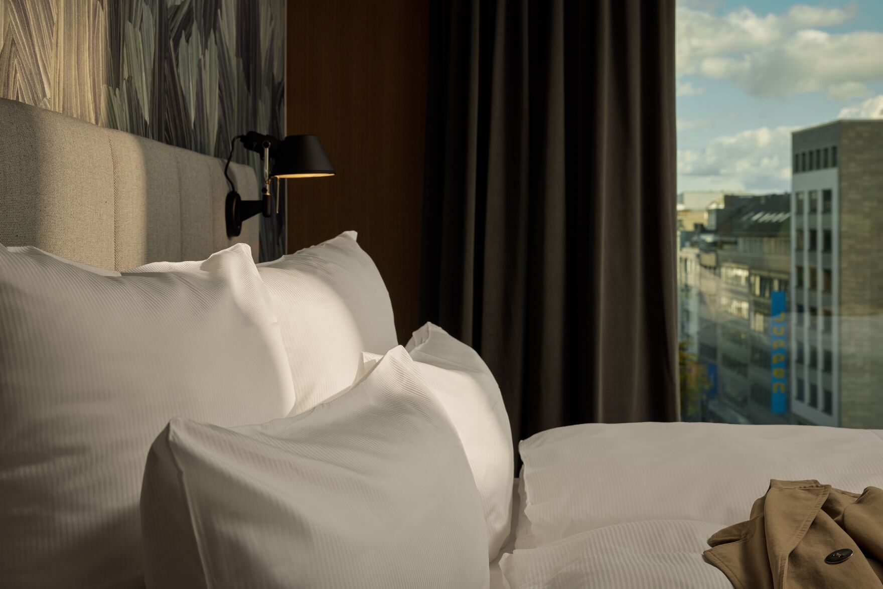 Designhotel Düsseldorf KöBogen The Cloud One seitlicher Blick über Doppelbett auf großes Fenster