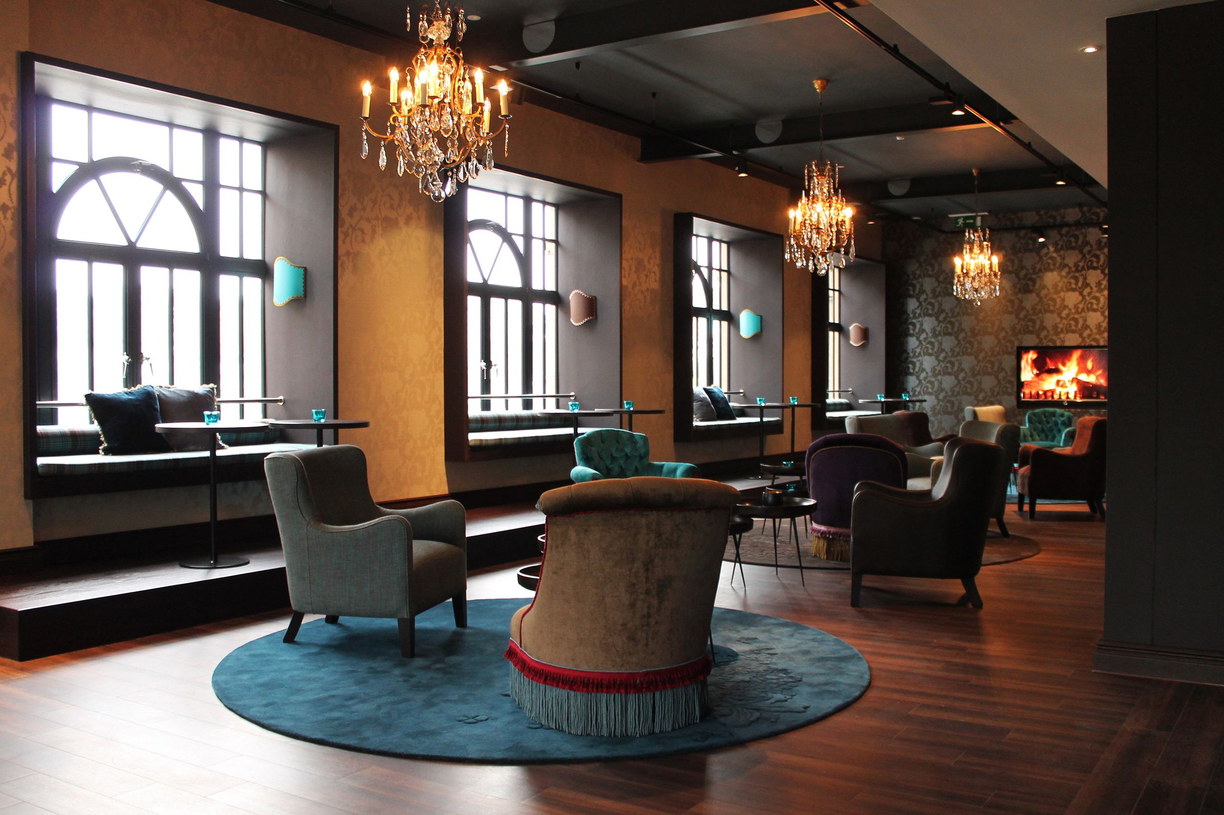 Designhotel Edinburgh Princes Motel One Lounge mit Sesseln und mehreren großen Fenstern