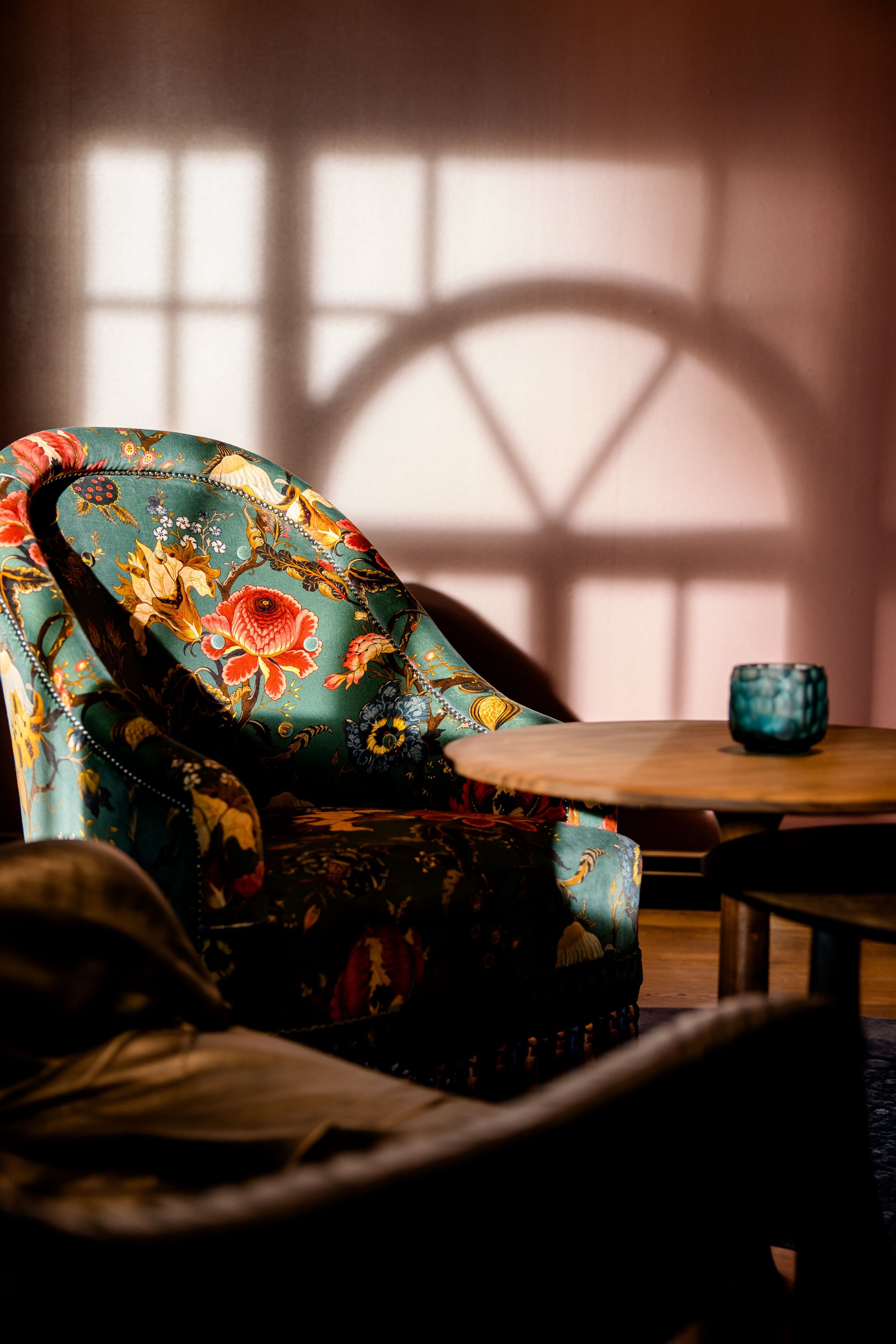 Hotel Edinburgh Princes Motel One Lounge mit Nahaufnahme auf gemusterten Sessel vor rosa Wand, der von der Sonne angestrahlt wird