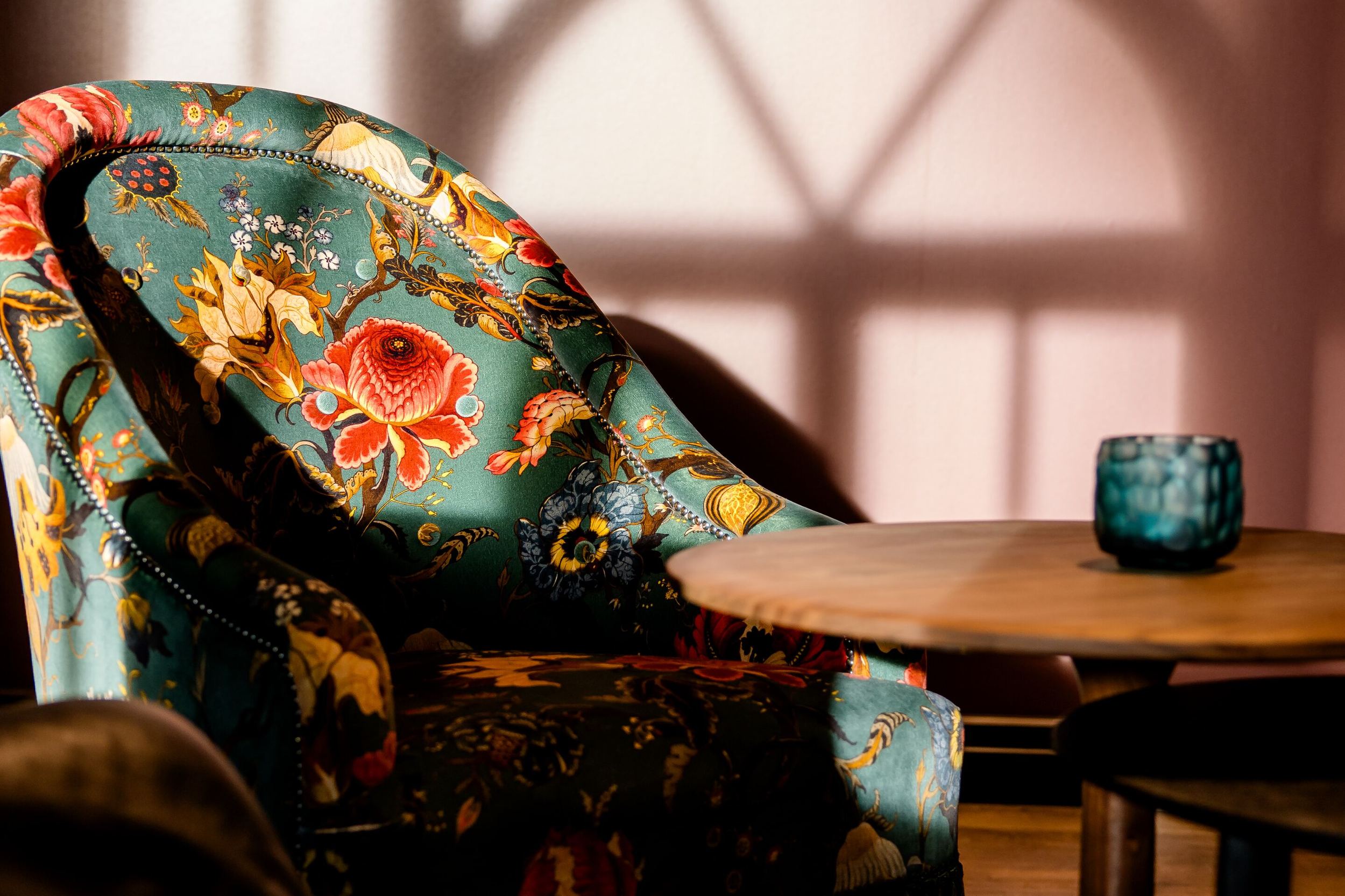 Hotel Edinburgh Princes Motel One Lounge mit Nahaufnahme auf gemusterten Sessel vor rosa Wand, der von der Sonne angestrahlt wird