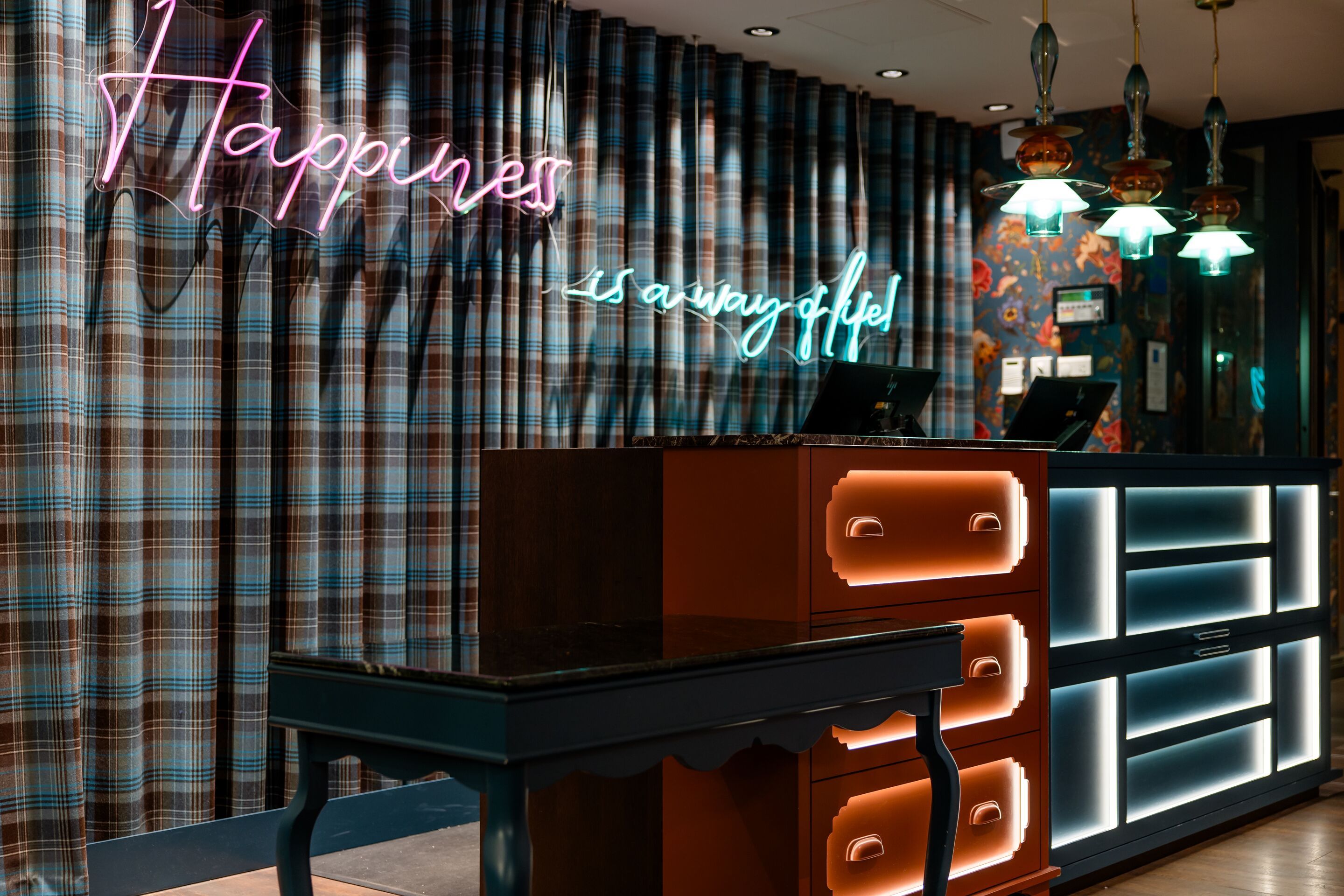 Hotel Edinburgh Princes Motel One Rezeption mit Neonschildern vor großen karierten Vorhängen