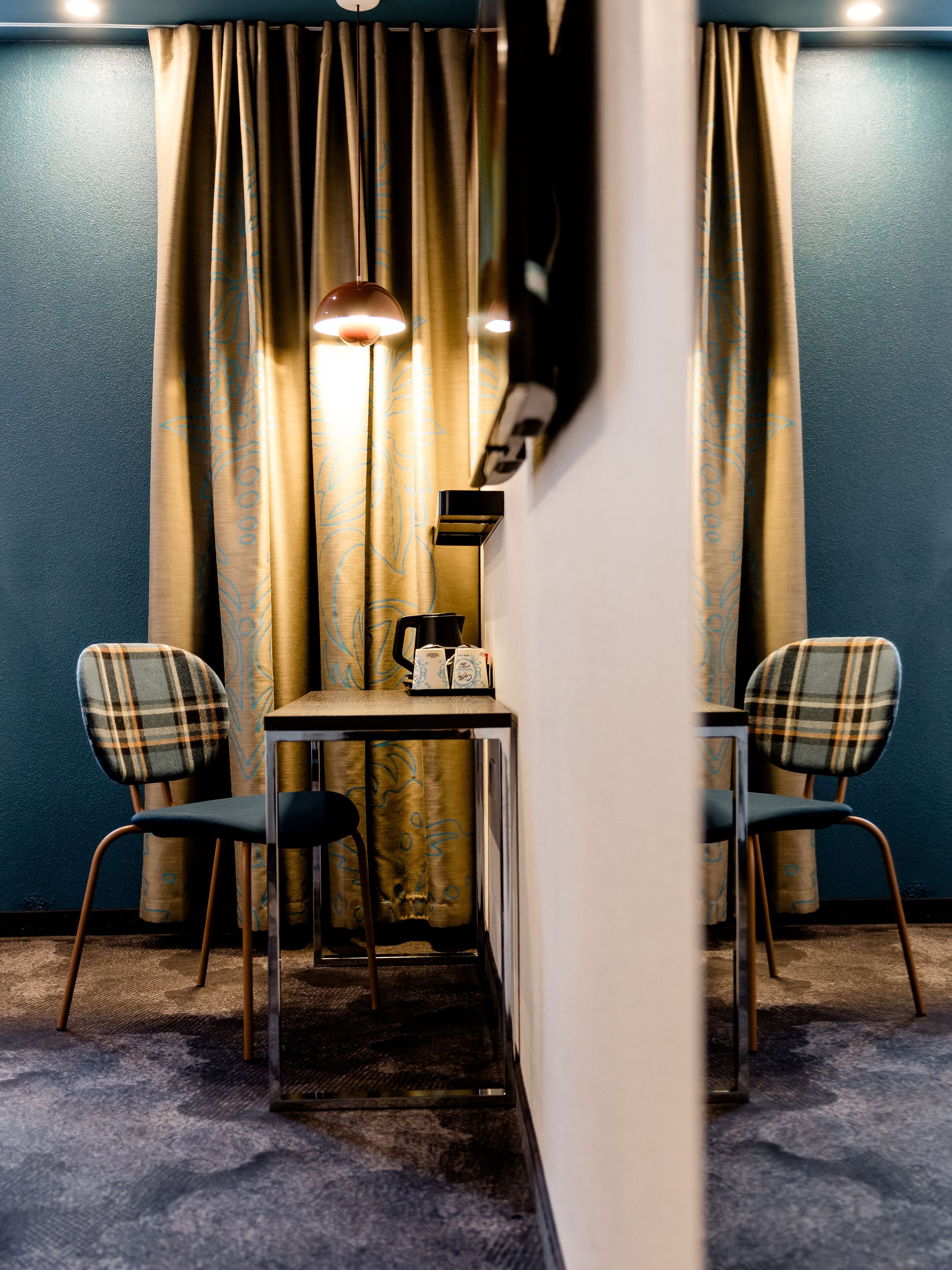 Hotel Edinburgh Princes Motel One Zimmer mit Blick auf einen großen Spiegel sowie Tisch mit Stuhl und TV an der Wand