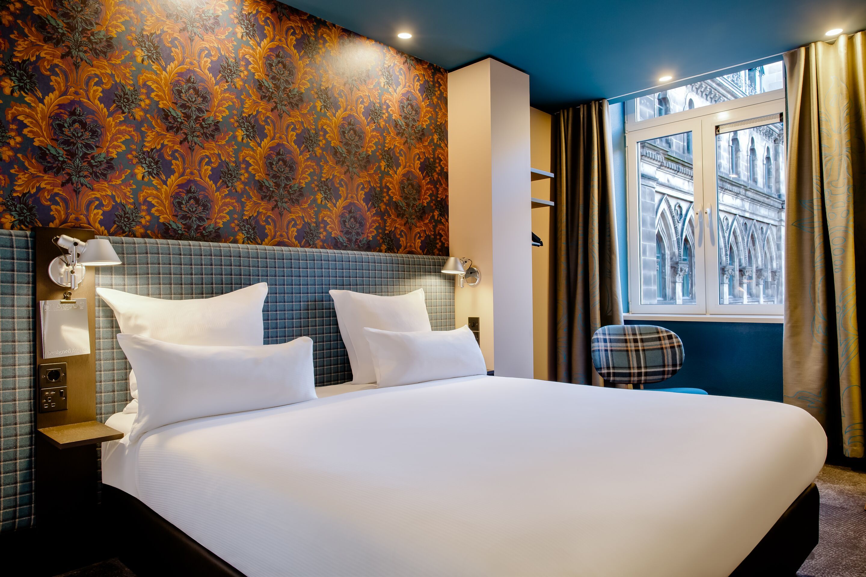 Hotel Edinburgh Princes Motel One helles Zimmer mit Blick auf ein großes Doppelbett sowie ein großes Fenster 