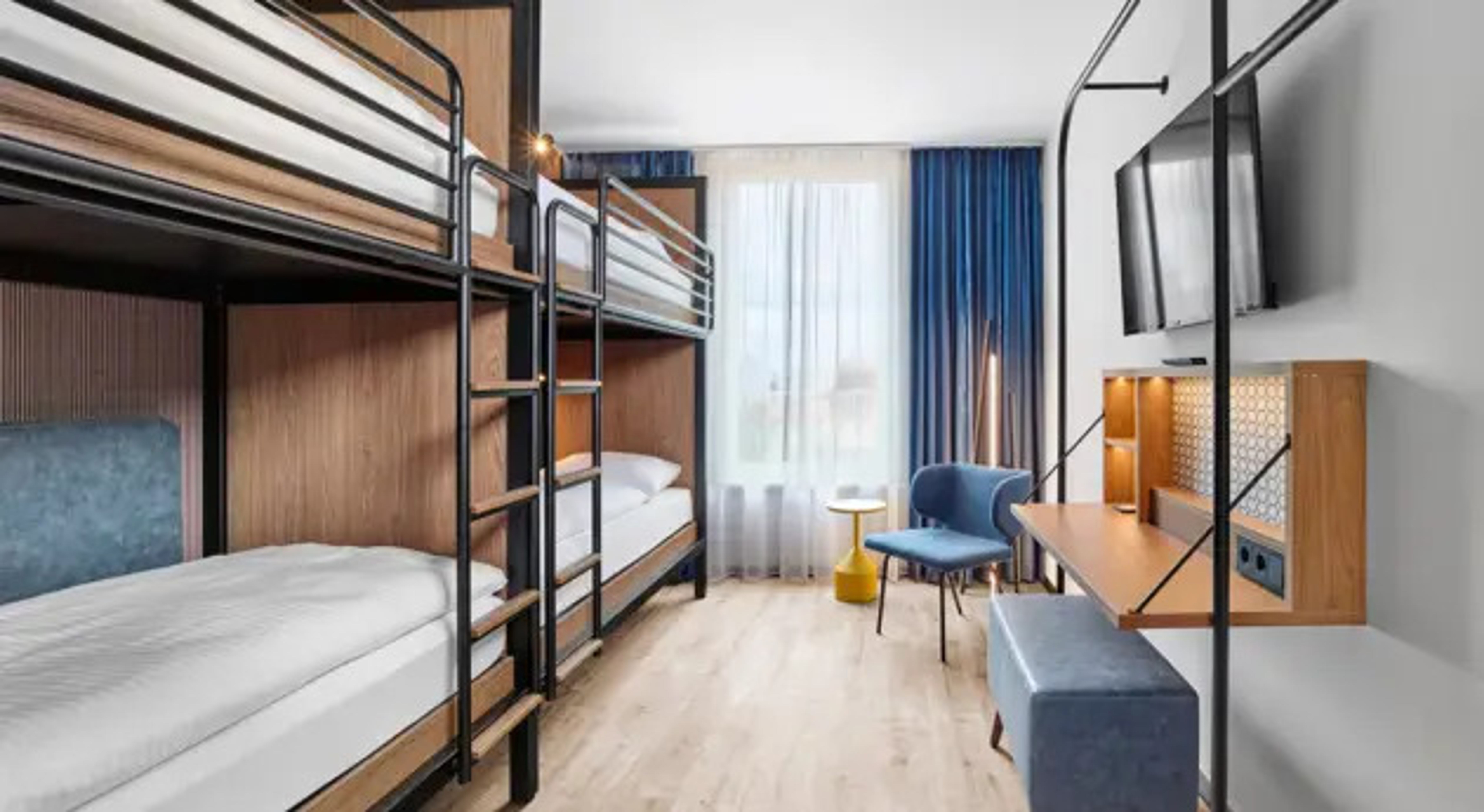 Hotel Erfurt-City Modernes Zimmer mit zwei Etagenbetten, großem Fenster, Schreibtisch, gemütlichem Stuhl und TV, hell und funktional gestaltet, ideal für Familien oder Gruppenreisende. Hotel Erfurt-City Modernes Zimmer mit zwei Etagenbetten, großem Fenster, Schreibtisch, gemütlichem Stuhl und TV, hell und funktional gestaltet, ideal für Familien oder Gruppenreisende.