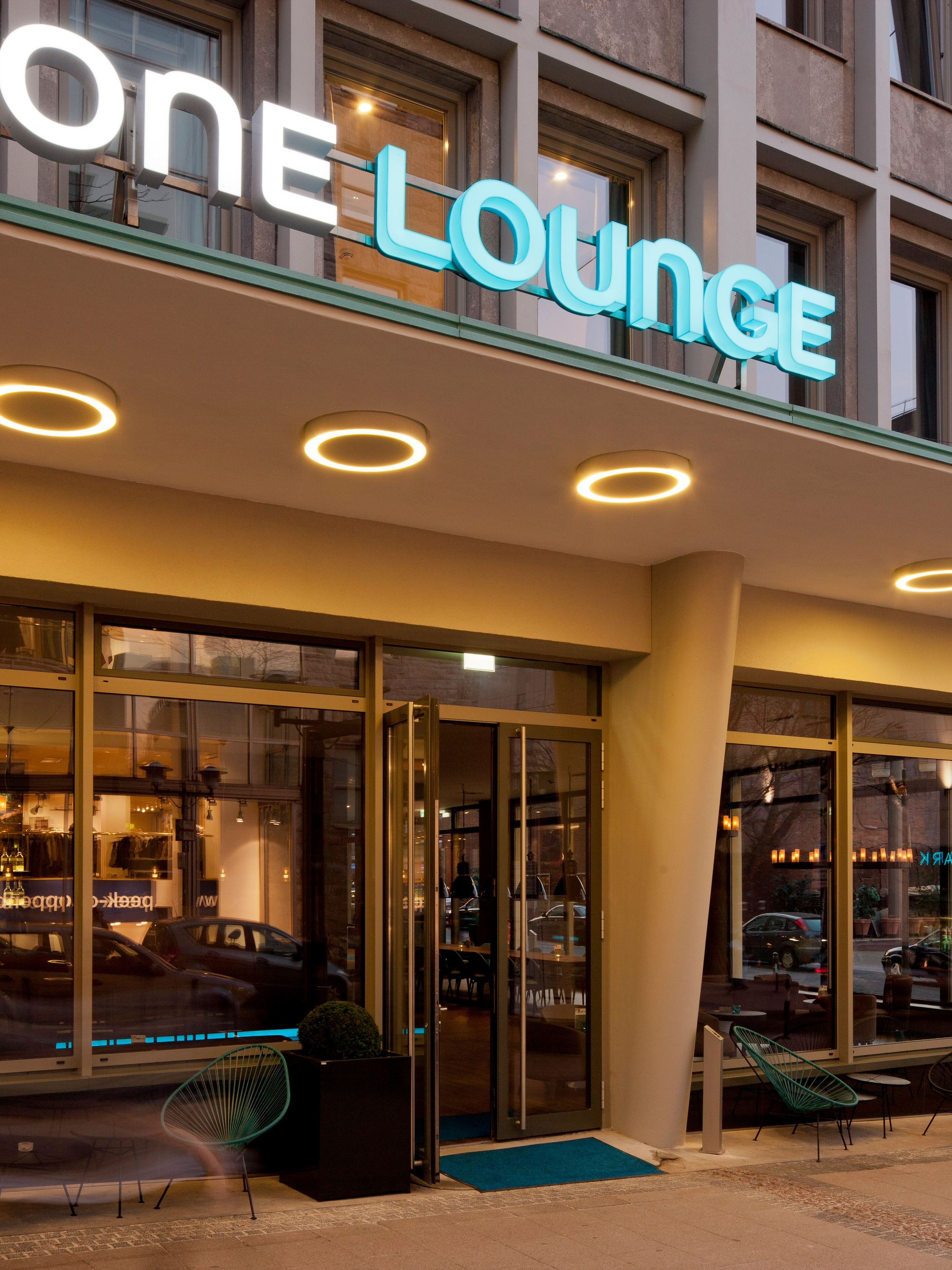 Hotel Essen Motel One Eingang zur One Lounge mit Logo über der Tür sowie Sitzgelegenheiten