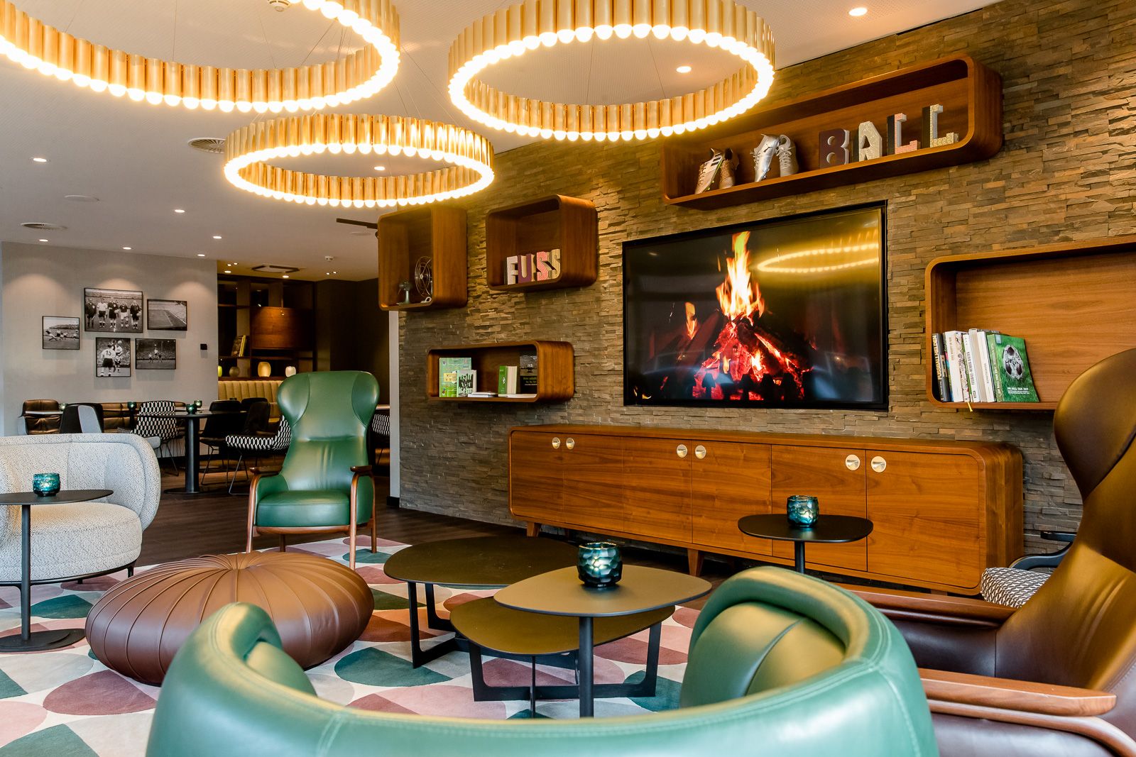 Designhotel Essen Motel One Lounge mit Sesseln und großem Fernseher an der Wand