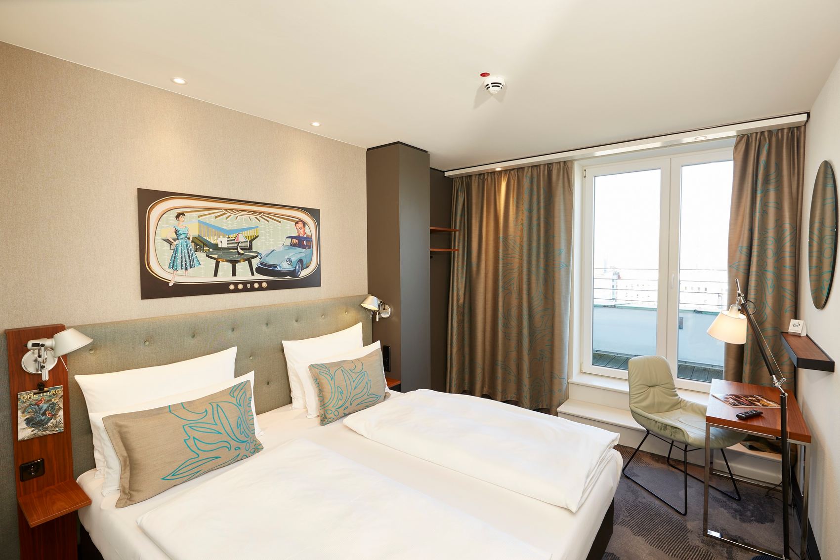Designhotel Essen Motel One Zimmer mit Doppelbett, Schreibtisch und Stuhl sowie Balkonzugang
