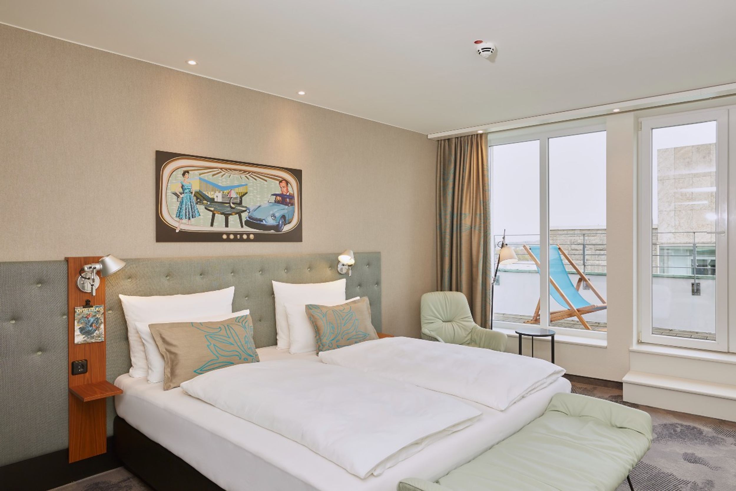 Hotel Essen Motel One Balkonzimmer mit großem Doppelbett sowie Liegestuhl auf dem Balkon