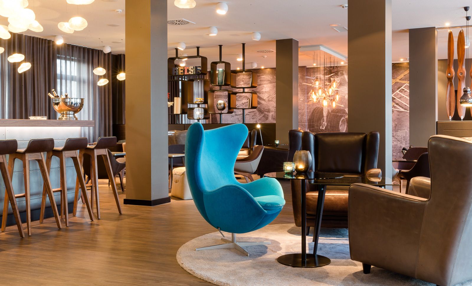 Hotel Frankfurt Airport Motel One offener Loungebereich mit mehreren Sesseln, Egg chair sowie Anschnitt der Bar