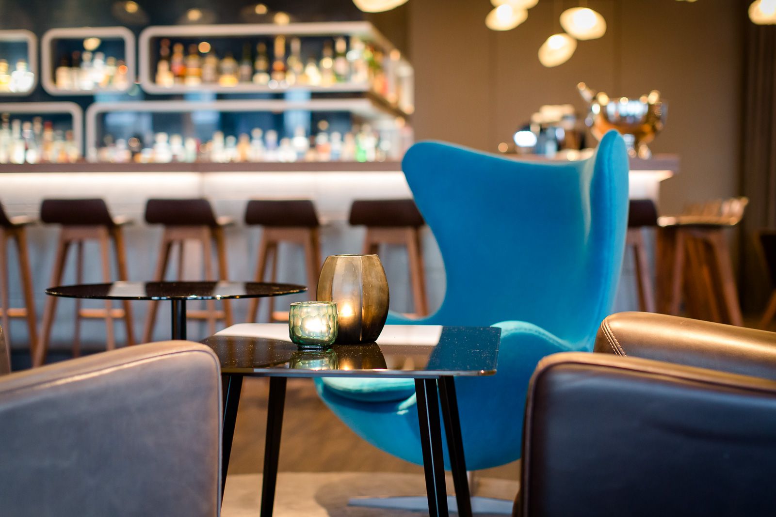Hotel Frankfurt Airport Motel One Nahaufnahme Egg chair in heller Lounge sowie Bar im Hintergrund
