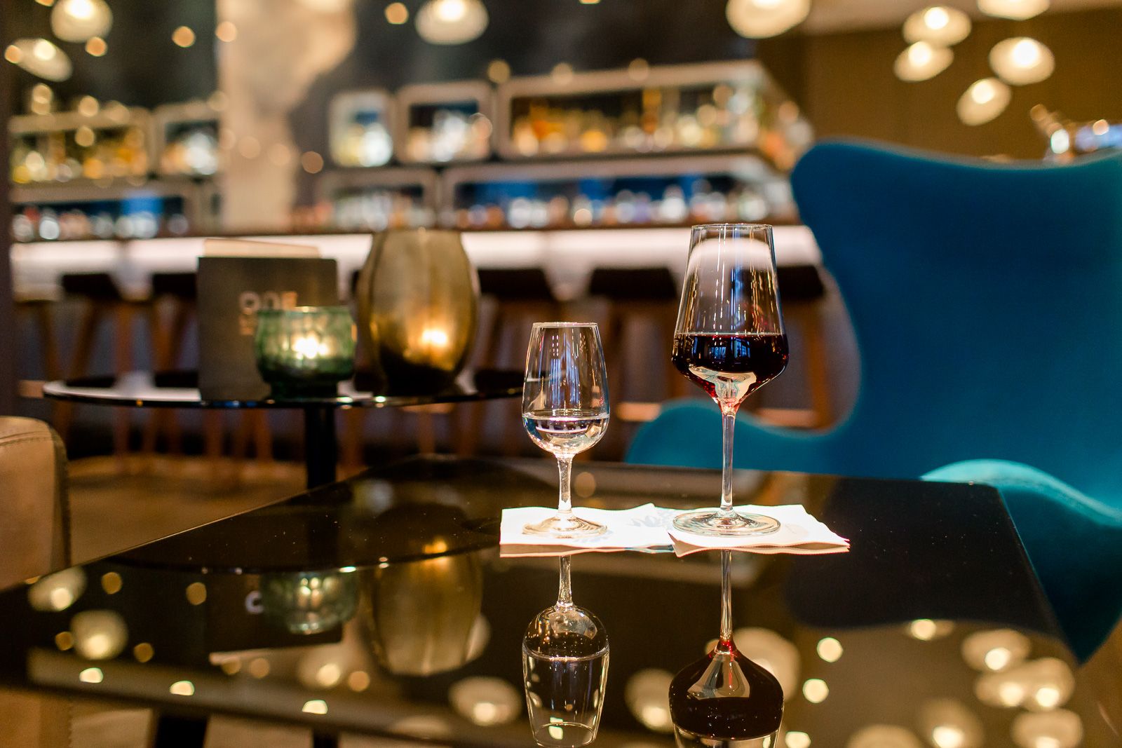 Designhotel Frankfurt Airport Motel One Lounge Blick auf ein Wasserglas sowie ein Rotweinglas