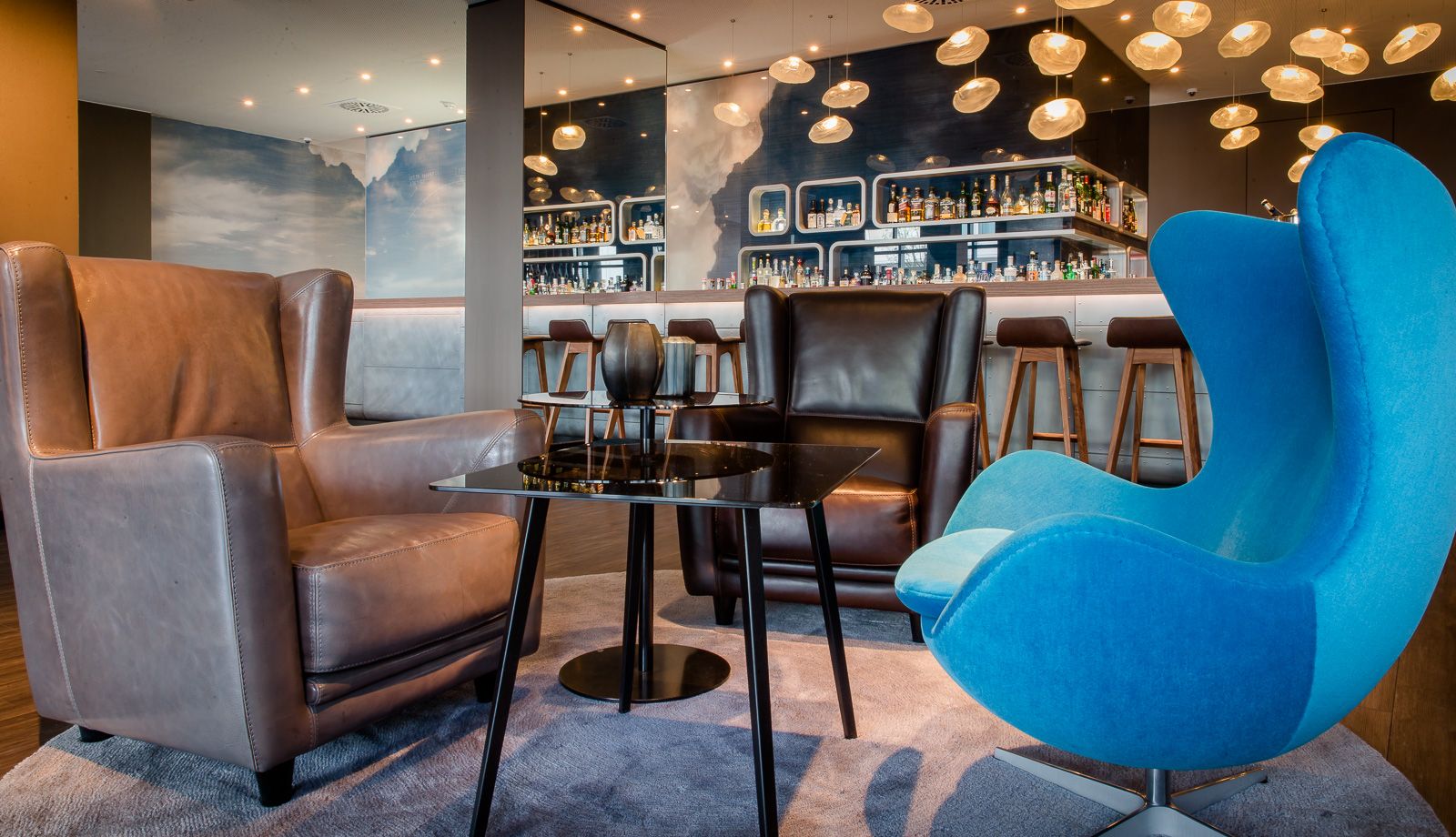 Hotel Frankfurt Airport Motel One helle Lounge mit Sessel und Egg chair sowie Bar im Hintergrund