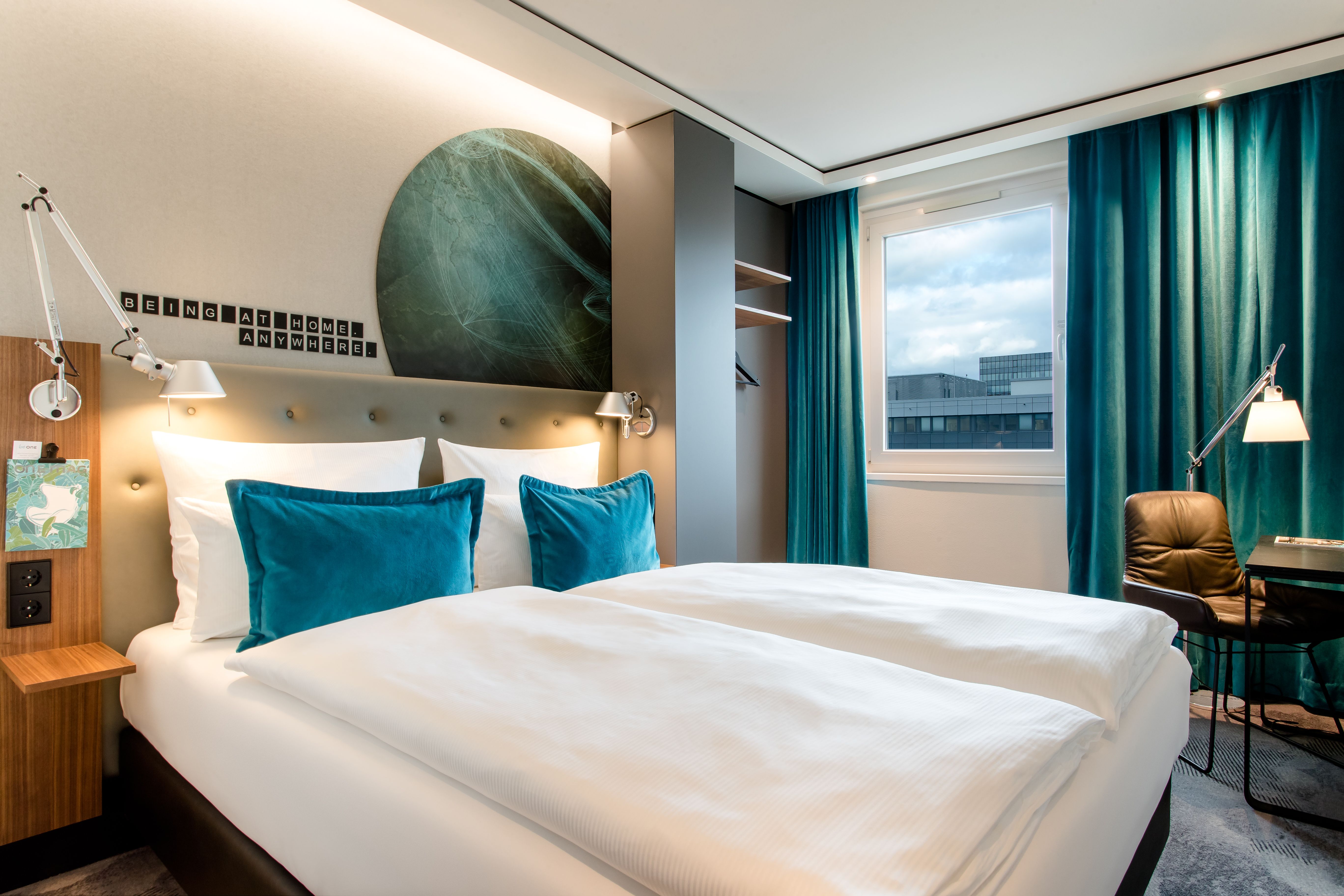 hotel Frankfurt Airport Motel One light-flooded room with comfortable double bed and table with chair 