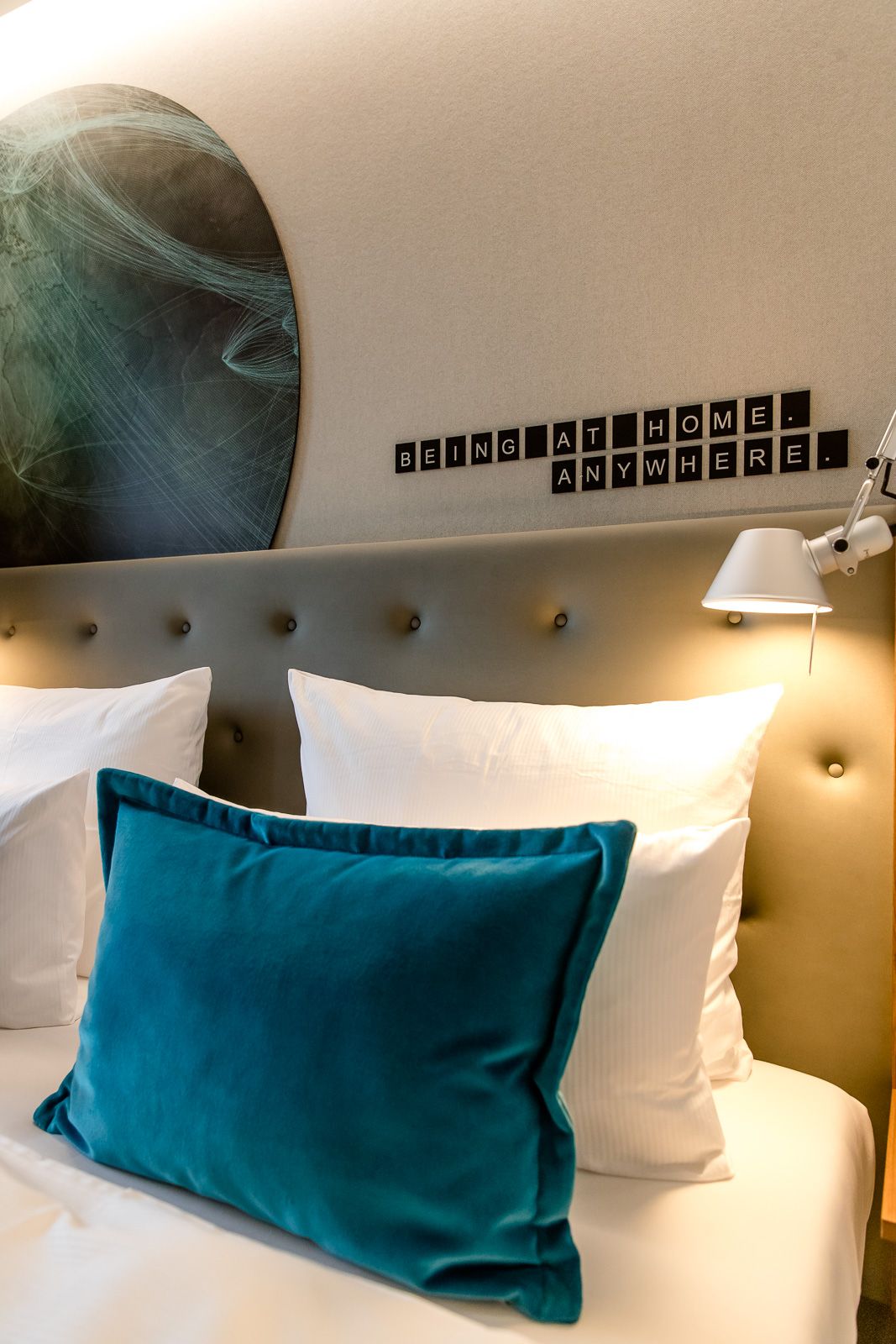 Hotel Frankfurt Airport Motel One seitlicher Blick auf ein Bett mit Zierkissen
