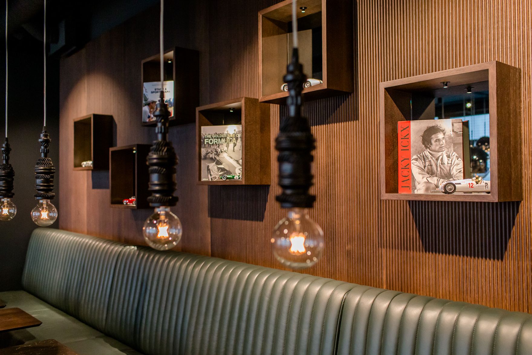 Hotel Frankfurt East Side Motel One lange Sitzbank und mehrere offene Regale mit Dekoration an der Wand