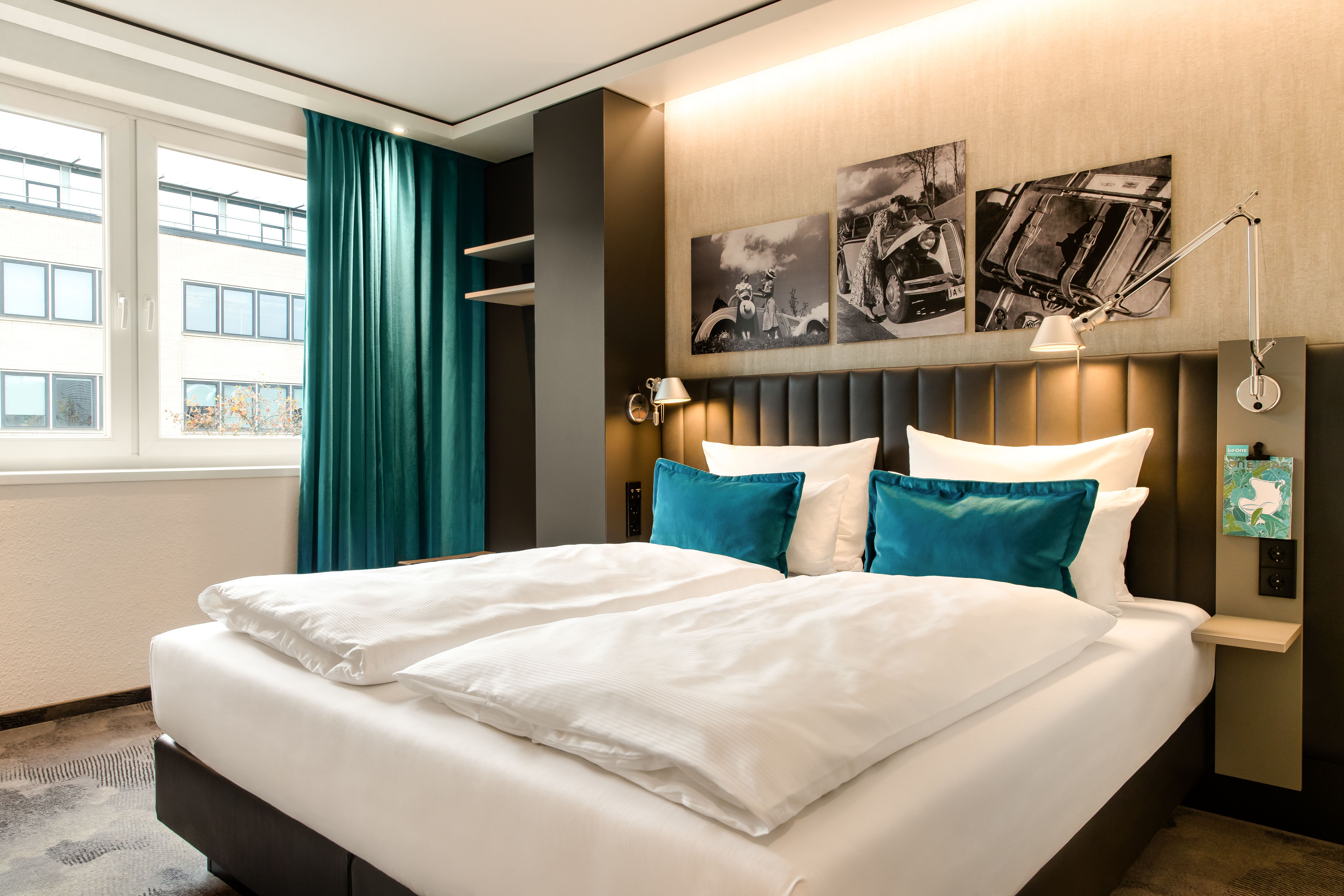 Hotel Frankfurt East Side Motel One lichtdurchflutetes Zimmer mit Doppelbett und großem Fenster