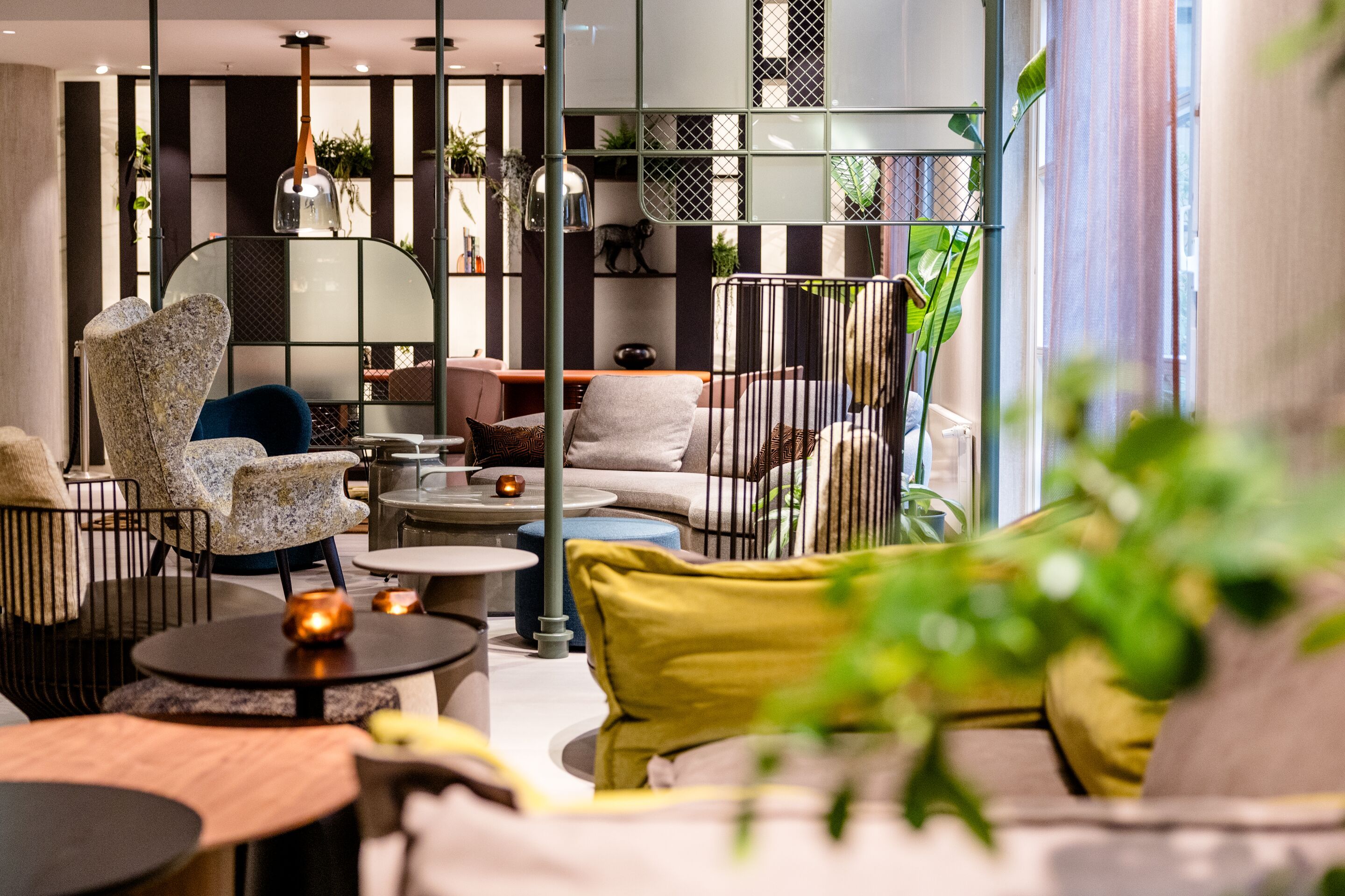 Hotel Frankfurt-Hauptbahnhof Motel One lichtdurchfluteter Lounge-Bereich mit gemütlichen Sesseln und Sofas sowie Tischen. Große Fenster schaffen eine helle, einladende Atmosphäre.