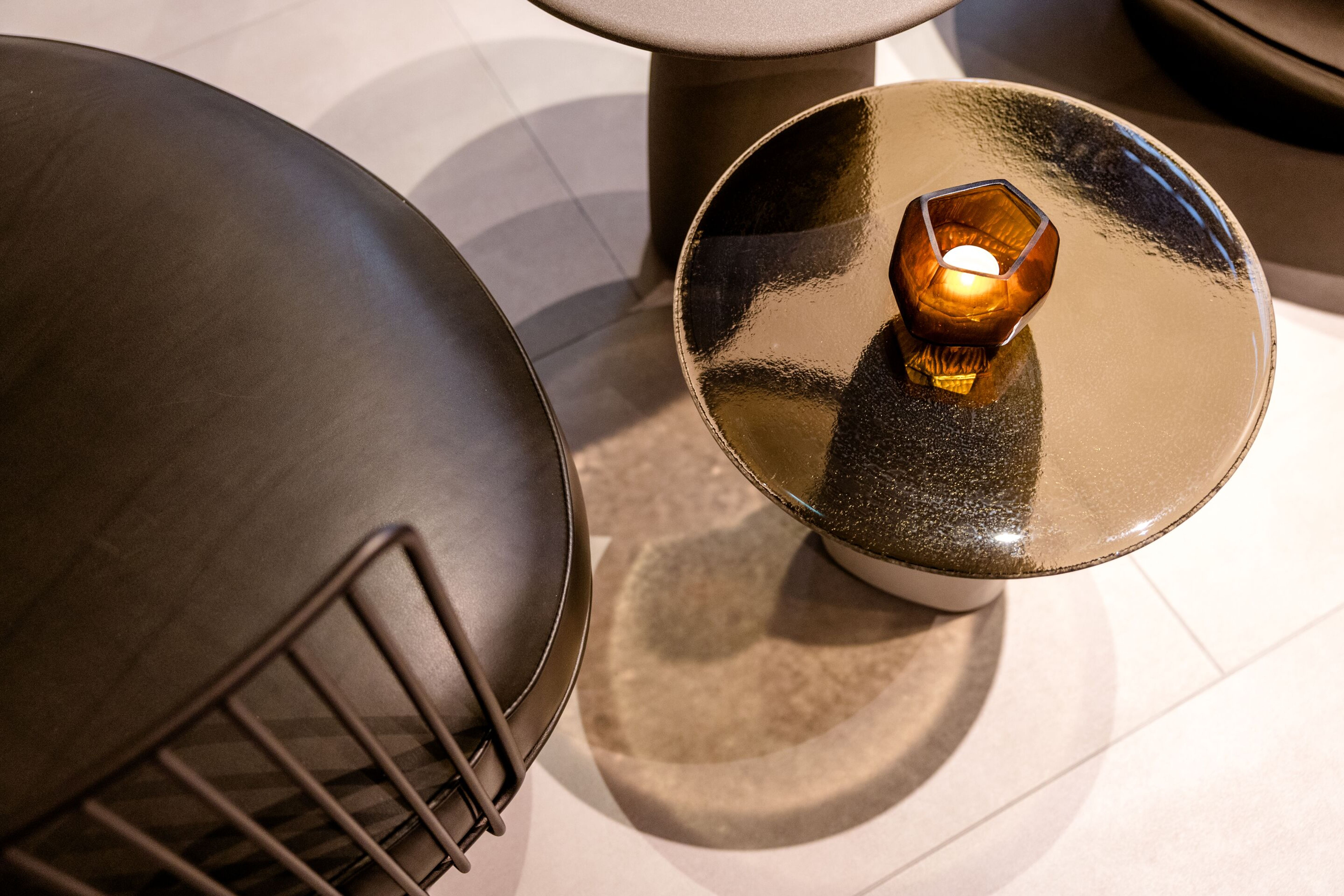 Hotel Frankfurt-Hauptbahnhof Motel One Blick von oben auf einen Beistelltisch mit glänzender Oberfläche und brennender Kerze, daneben ein schwarzer Stuhl mit Metallgestell. Hotel Frankfurt-Hauptbahnhof Motel One Blick von oben auf einen Beistelltisch mit glänzender Oberfläche und brennender Kerze, daneben ein schwarzer Stuhl mit Metallgestell.