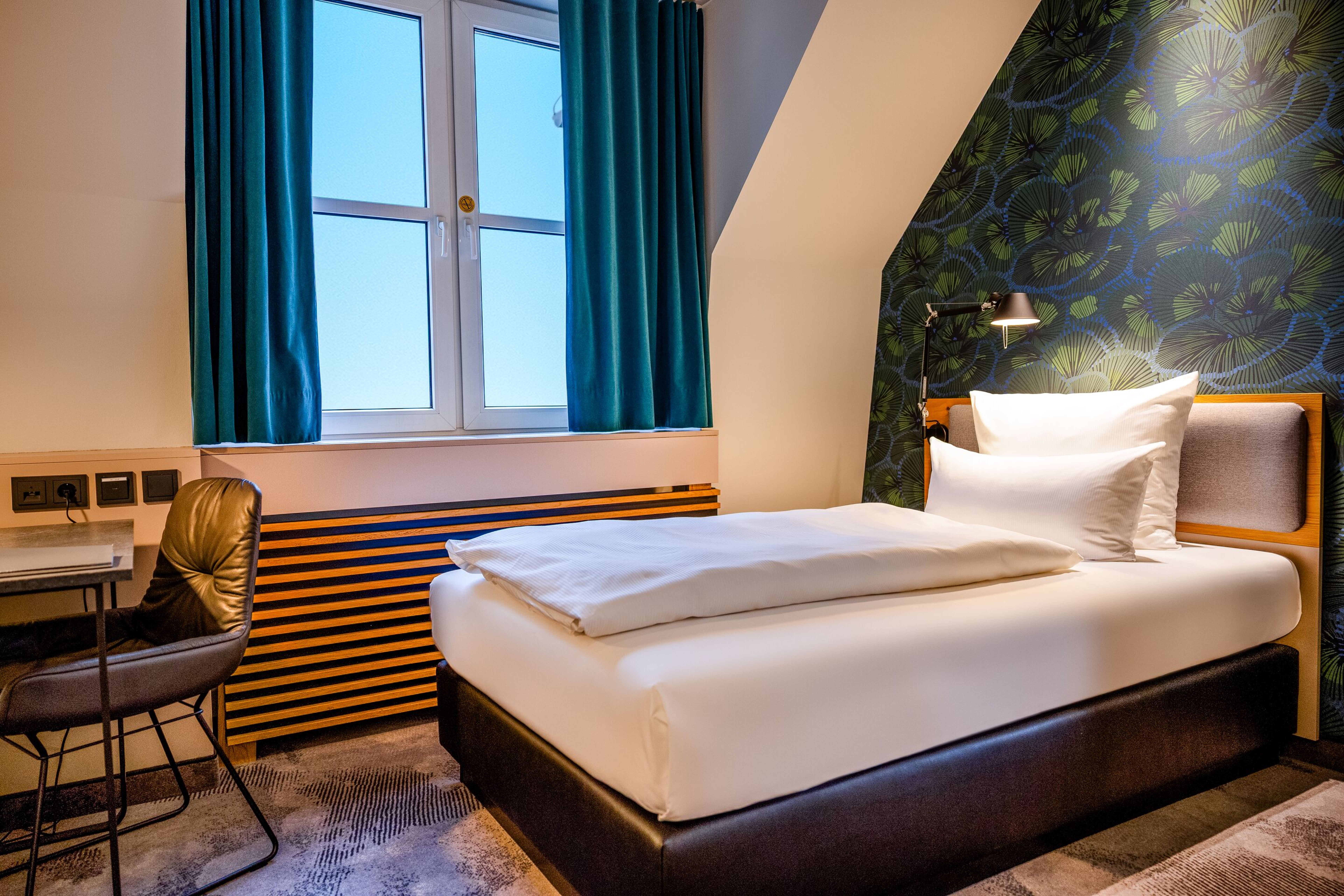 Hotel Motel One Frankfurt-Hauptbahnhof Gemütliches Einzelzimmer mit hochwertigem Bett, sauberen weißen Bettwäsche, stilvoller Tapete und großem Fenster mit Blick nach draußen. Modernes, einladendes Ambiente ideal für entspannte Nächte. Hotel Motel One Frankfurt-Hauptbahnhof Gemütliches Einzelzimmer mit hochwertigem Bett, sauberen weißen Bettwäsche, stilvoller Tapete und großem Fenster mit Blick nach draußen. Modernes, einladendes Ambiente ideal für entspannte Nächte.