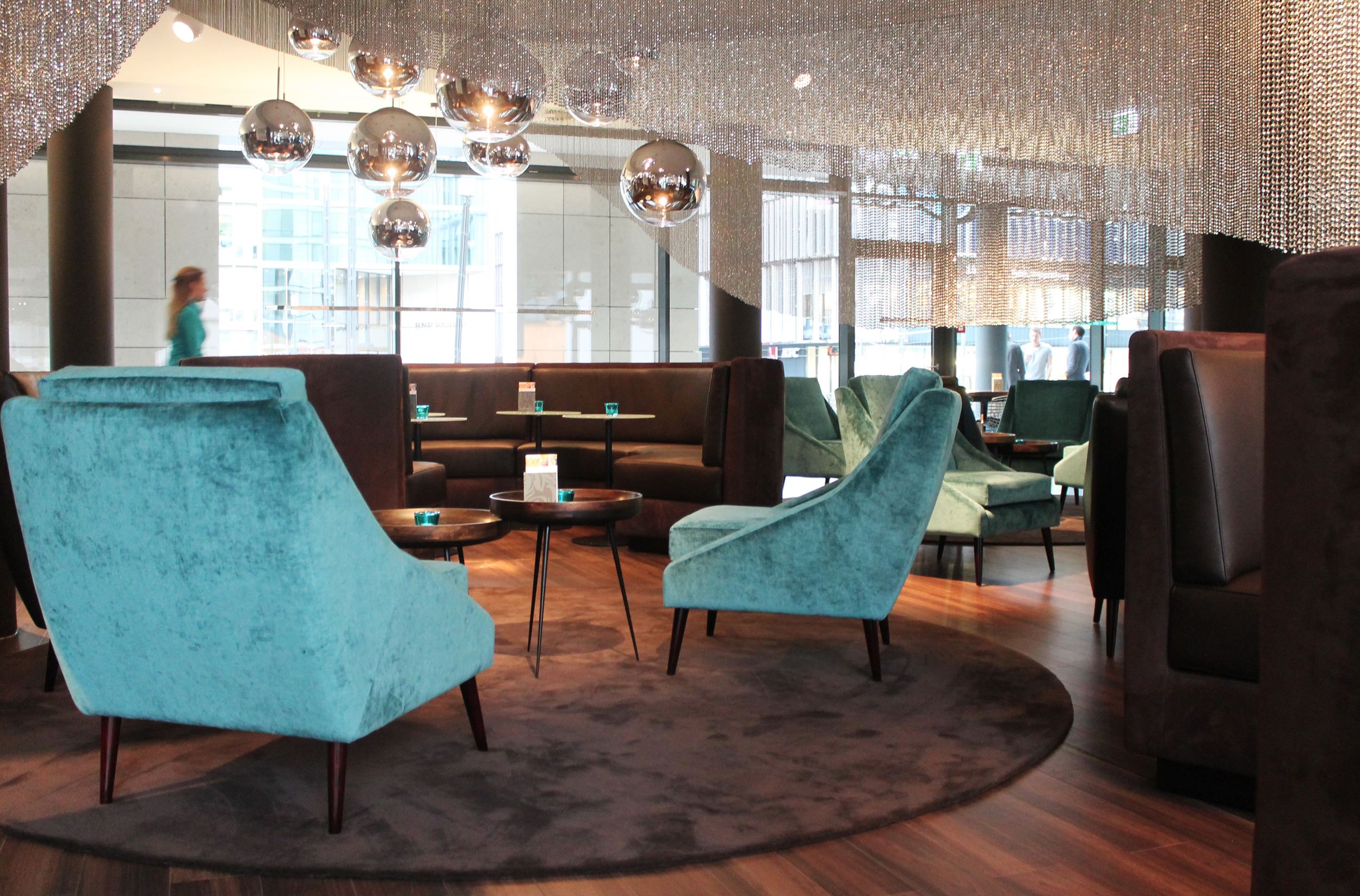 Hotel Frankfurt Messe Motel One helle Lounge mit mehreren Sesseln und Sofas