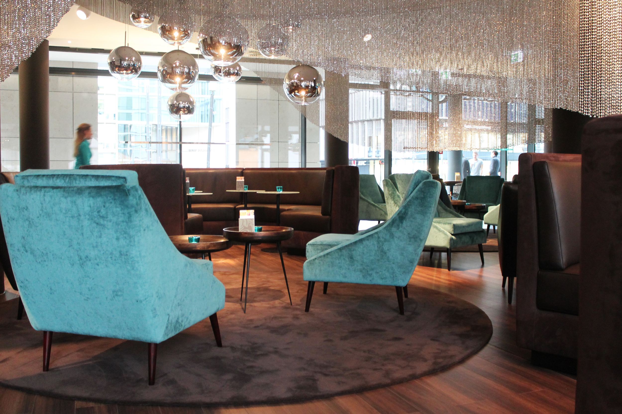 Hotel Frankfurt Messe Motel One helle Lounge mit mehreren Sesseln und Sofas