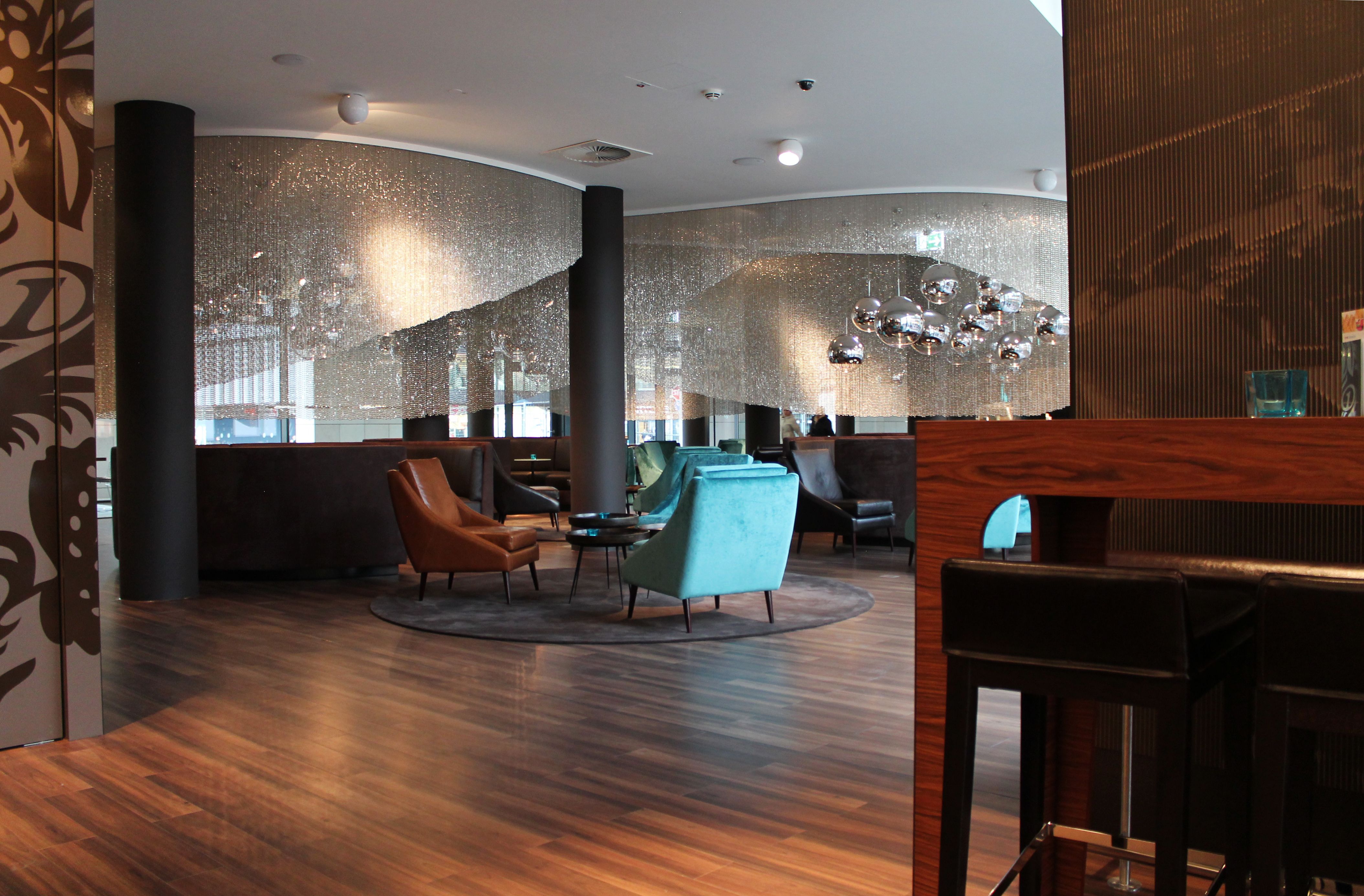 Designhotel Frankfurt Messe Motel One große und helle Lounge mit mehreren Sitzgelegenheiten
