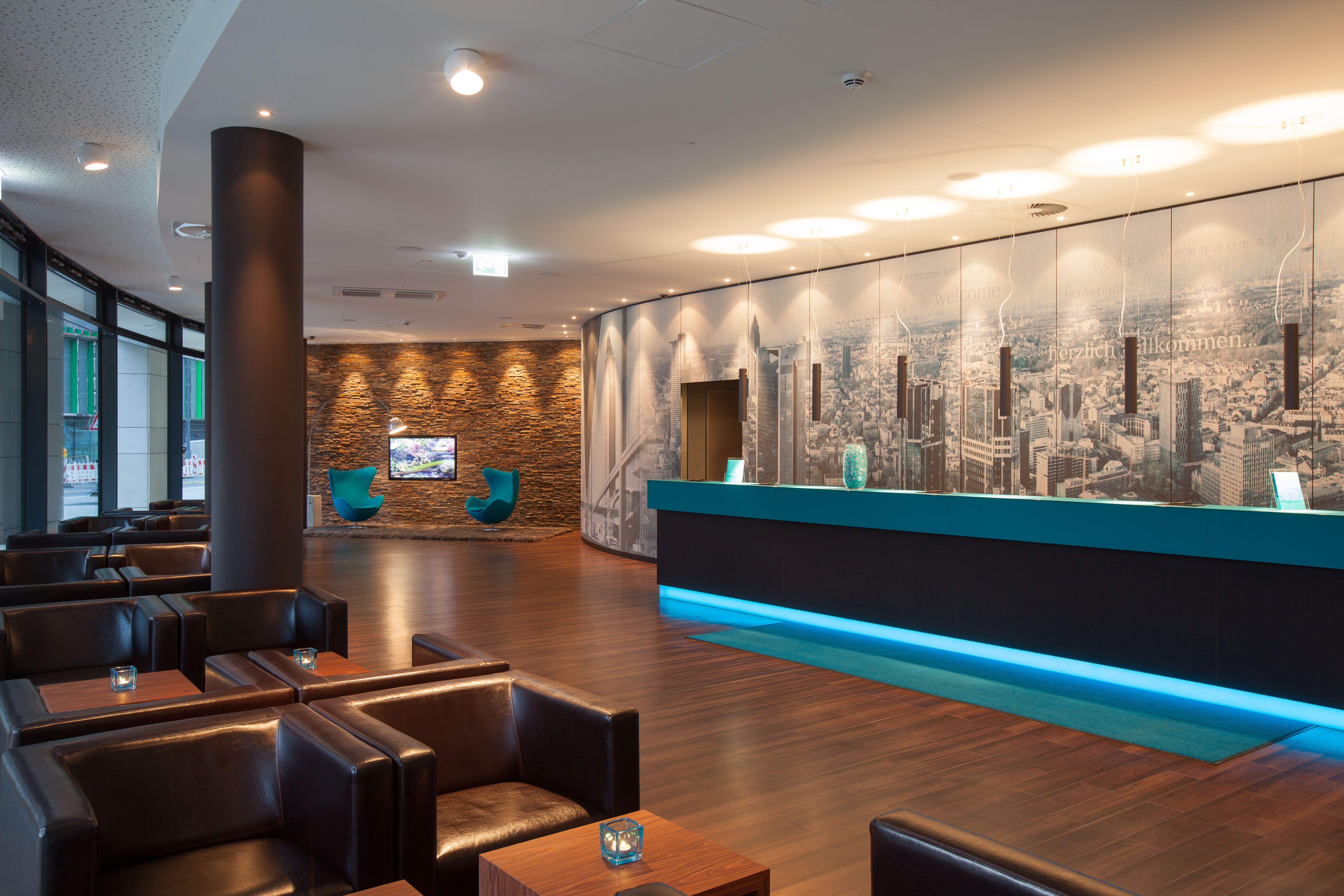 Hotel Frankfurt Messe Motel One Eingangsbereich mit Sitzgelegenheiten, Rezeption sowie zwei Egg chairs
