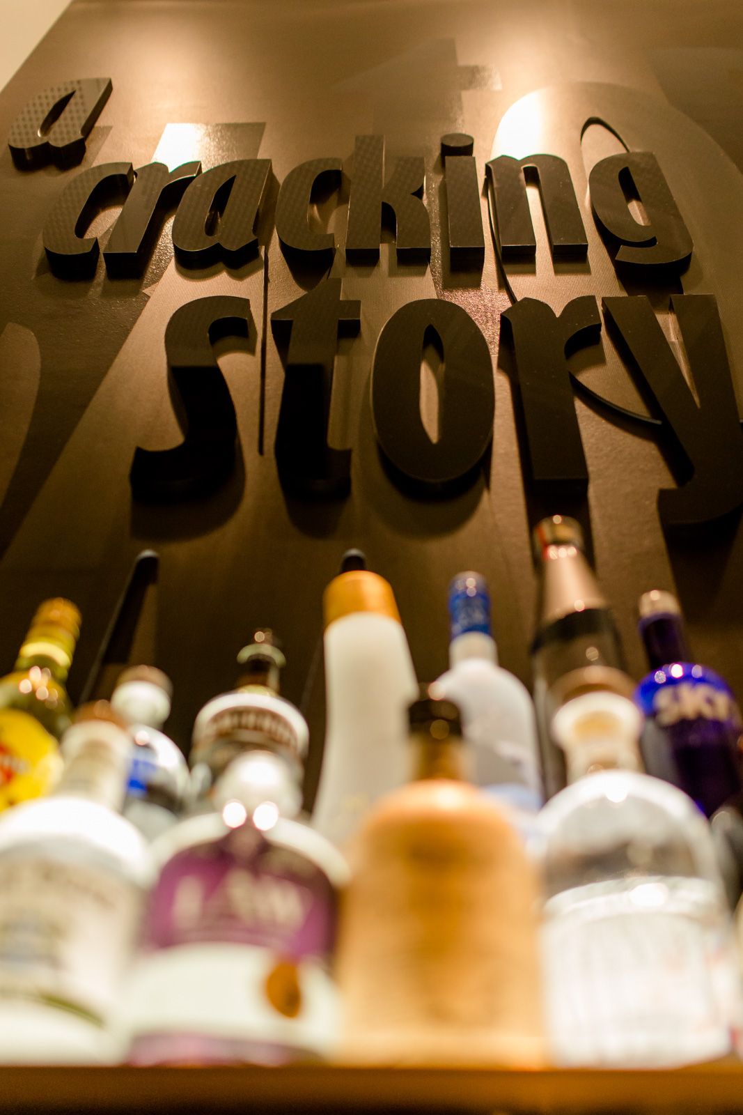 Hotel Frankfurt Römer Motel One Nahaufnahme auf Spirituosen und Schriftzug "a cracking story" an der Wand