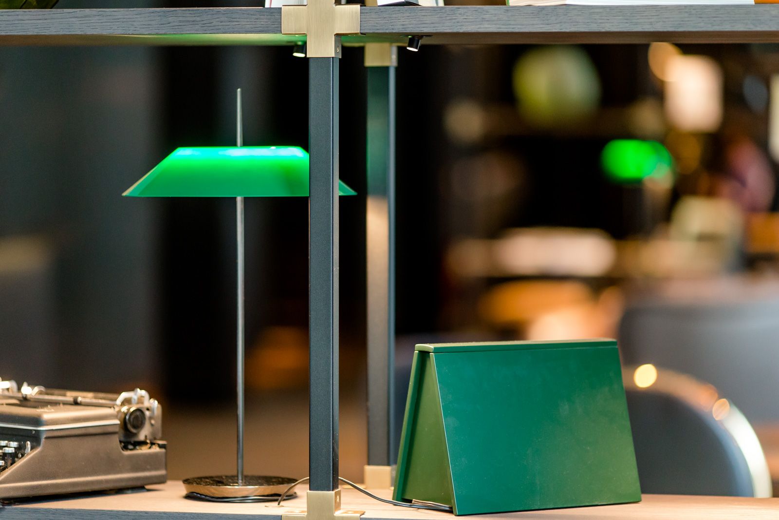 Designhotel Frankfurt Römer Motel One Detailaufnahme offenes Regal mit grünem Buch sowie Lampe mit grünem Lampenschirm