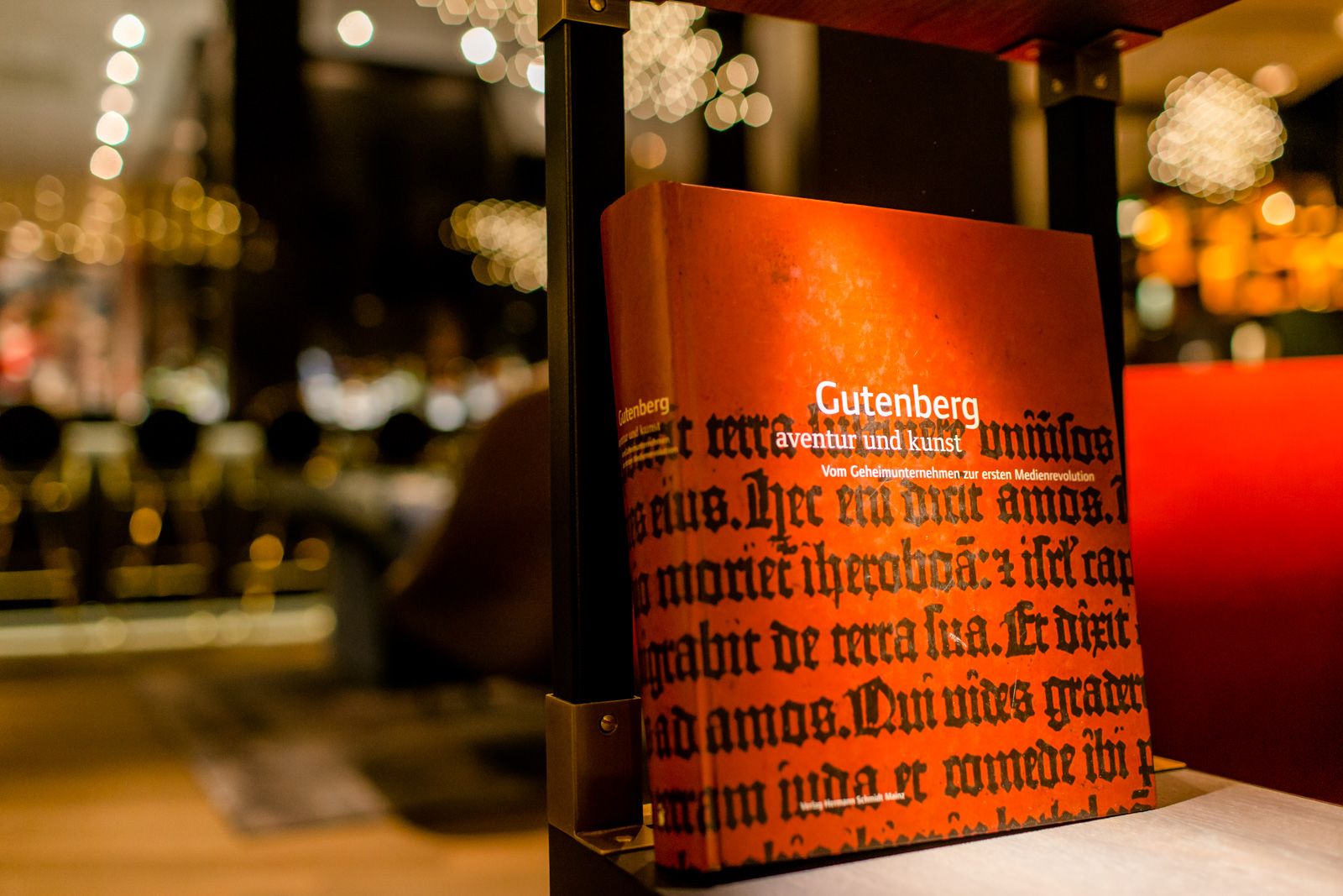 Designhotel Frankfurt Römer Motel One Nahaufnahme auf Gutenberg Buch in offenem Regal in der Lounge