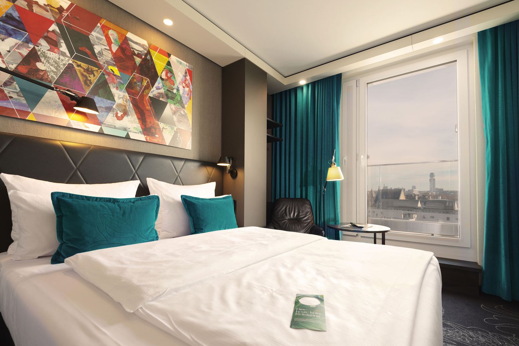 Hotel Frankfurt Römer Motel One helles Zimmer mit Doppelbett und Aussicht auf die Stadt Frankfurt