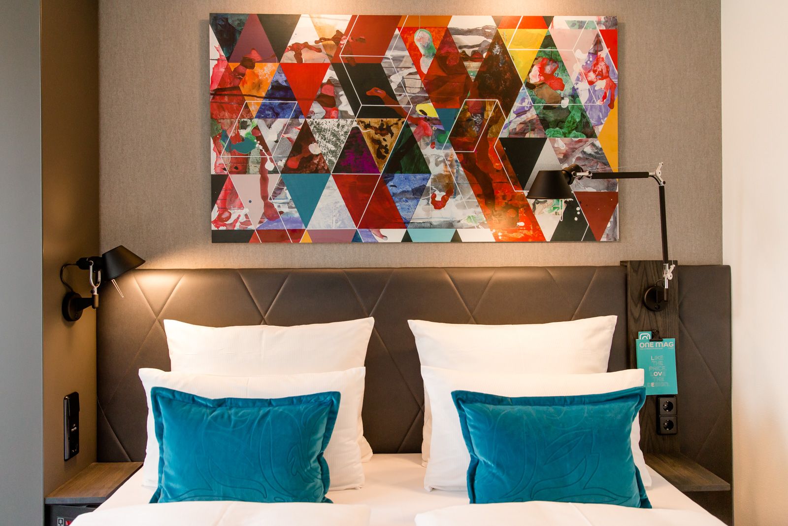 Designhotel Frankfurt Römer Motel One Doppelbett mit weißen Kopfkissen sowie zwei Zierkissen in türkis