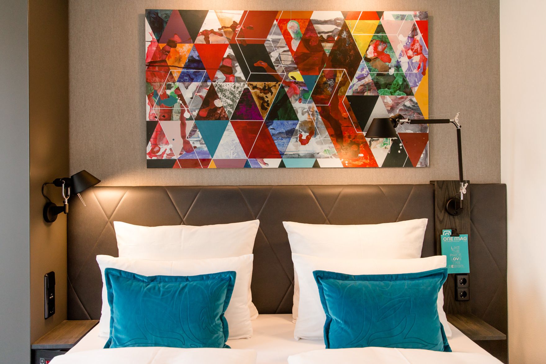 designhotel Frankfurt Römer Motel One double bed with white pillows and two decorative pillows in turquoise