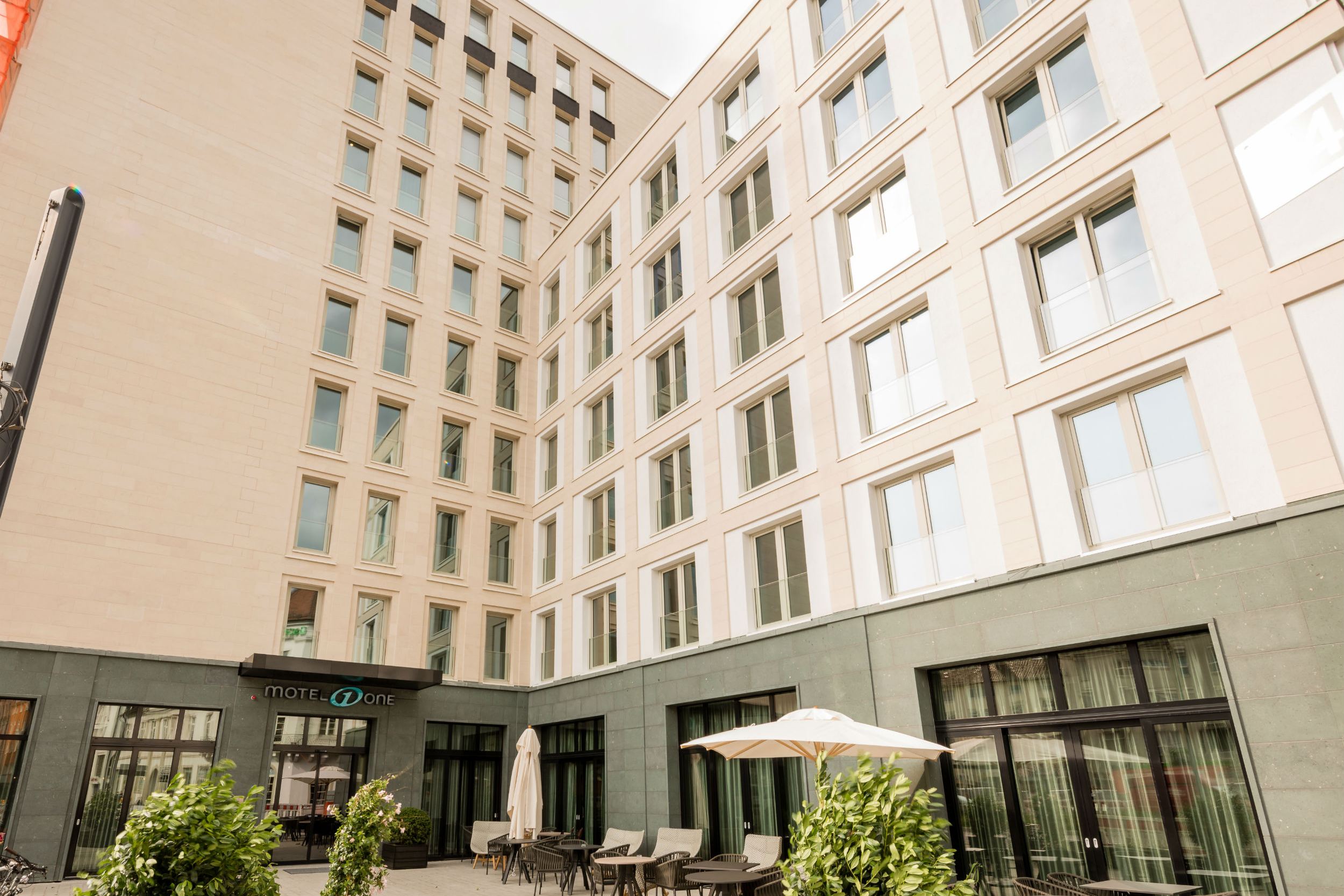 Hotel Freiburg Motel One Fassade und Außenbereich mit Sitzmöglichkeiten