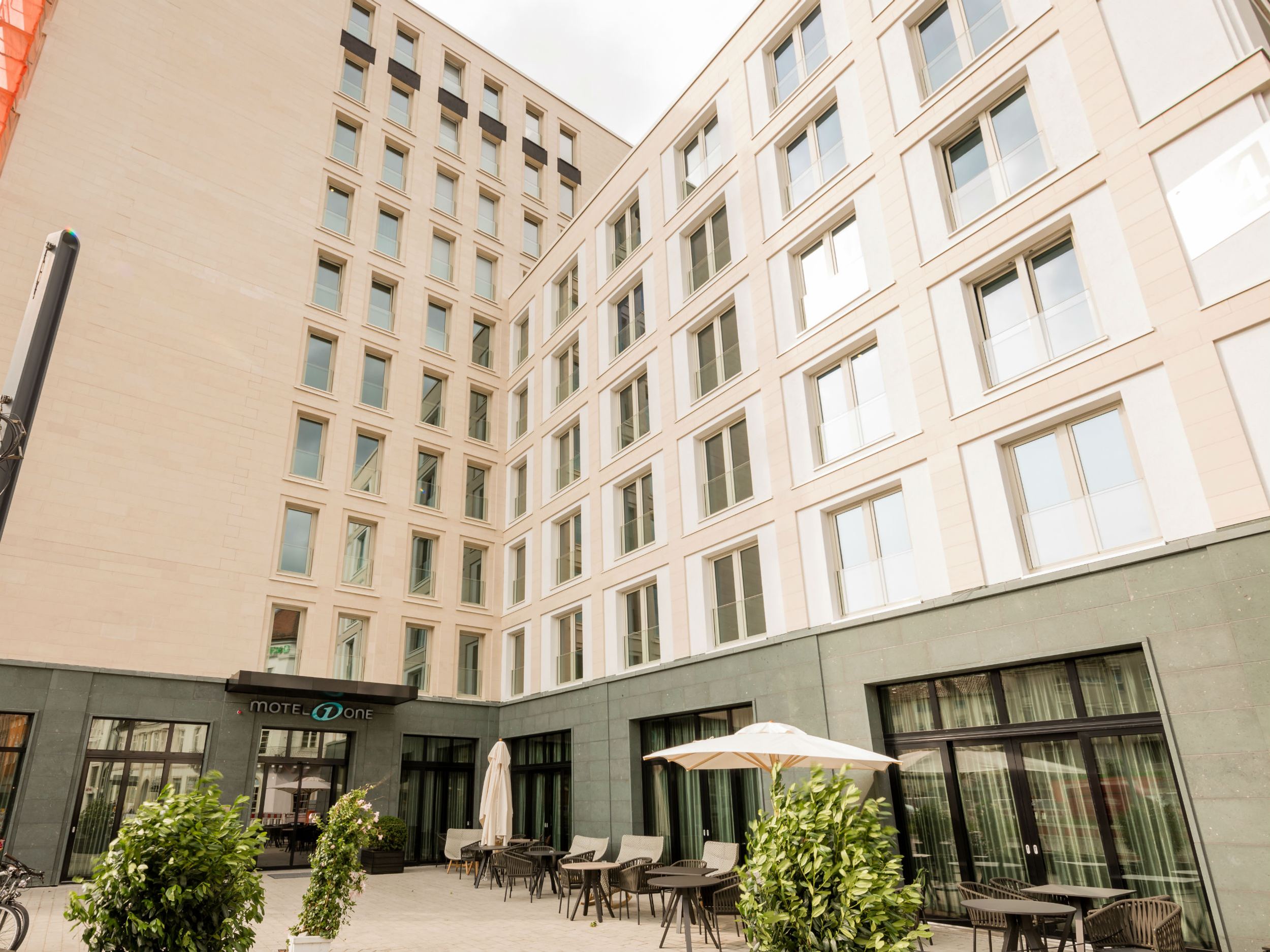 Hotel Freiburg Motel One Fassade und Außenbereich mit Sitzmöglichkeiten