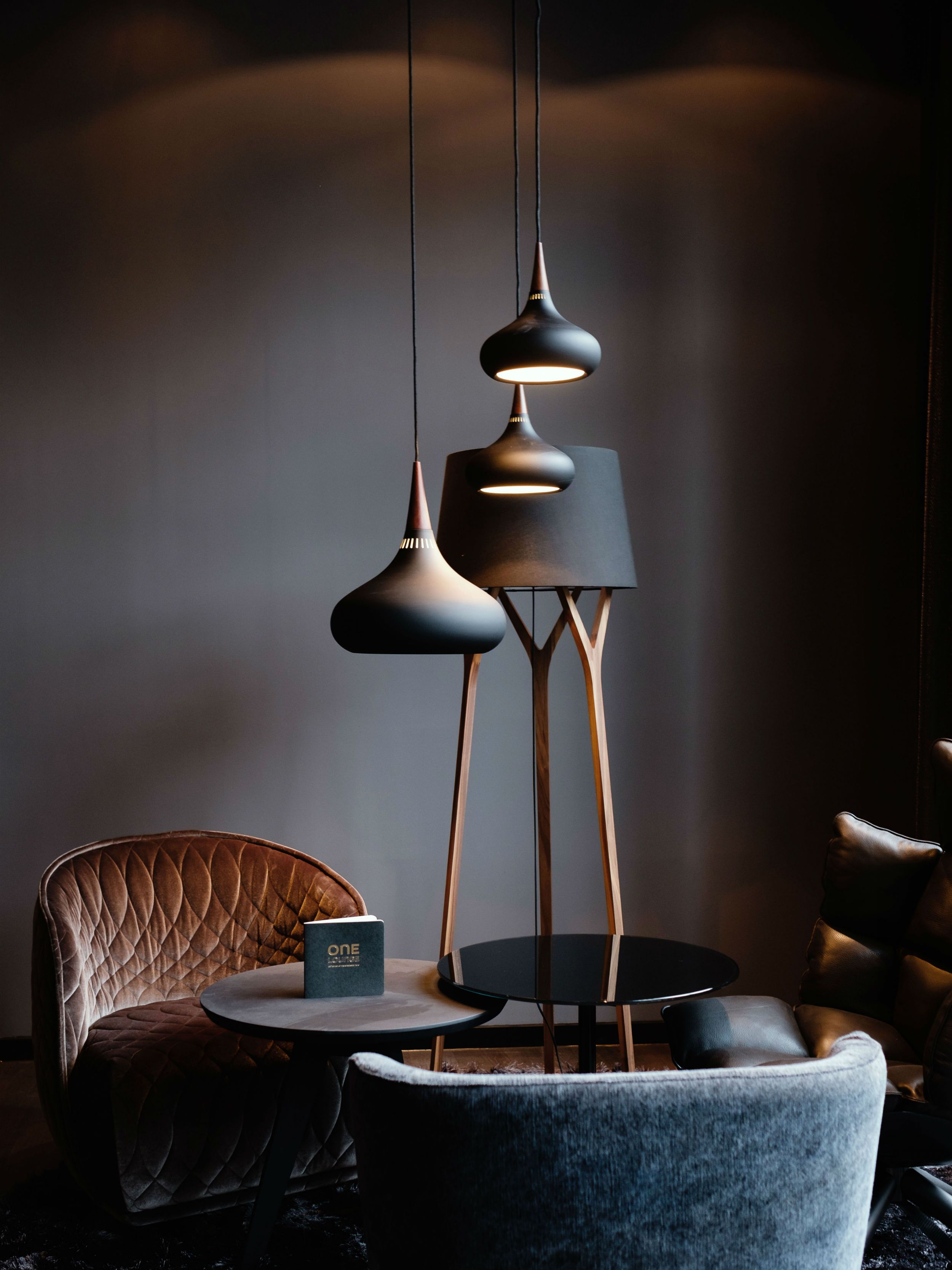 Hotel Freiburg Motel One Lounge mit drei Sesseln und Tisch sowie Designerlampe