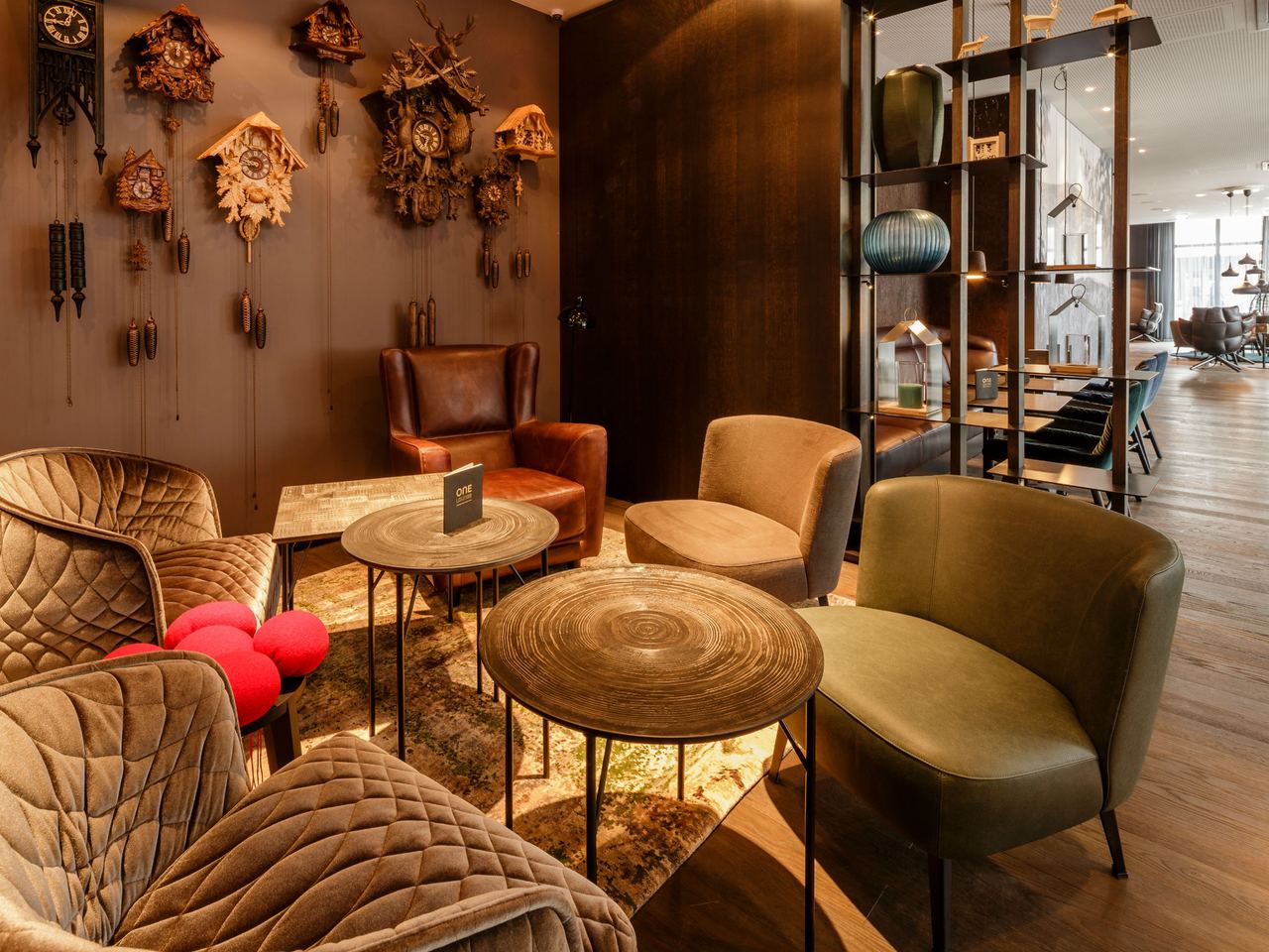 Hotel Freiburg Motel One Lounge mit Sitzbereich und Kuckucksuhren an der Wand