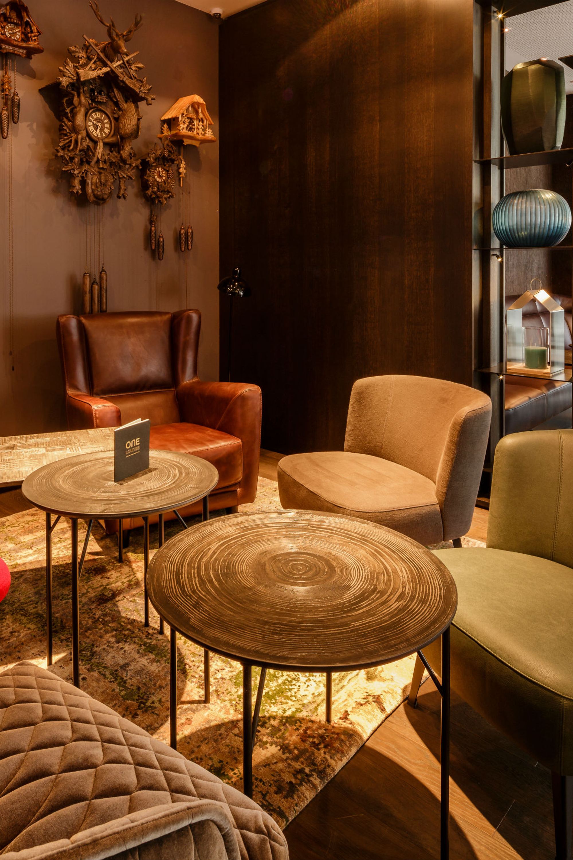 Hotel Freiburg Motel One Lounge mit Sitzbereich und Kuckucksuhren an der Wand