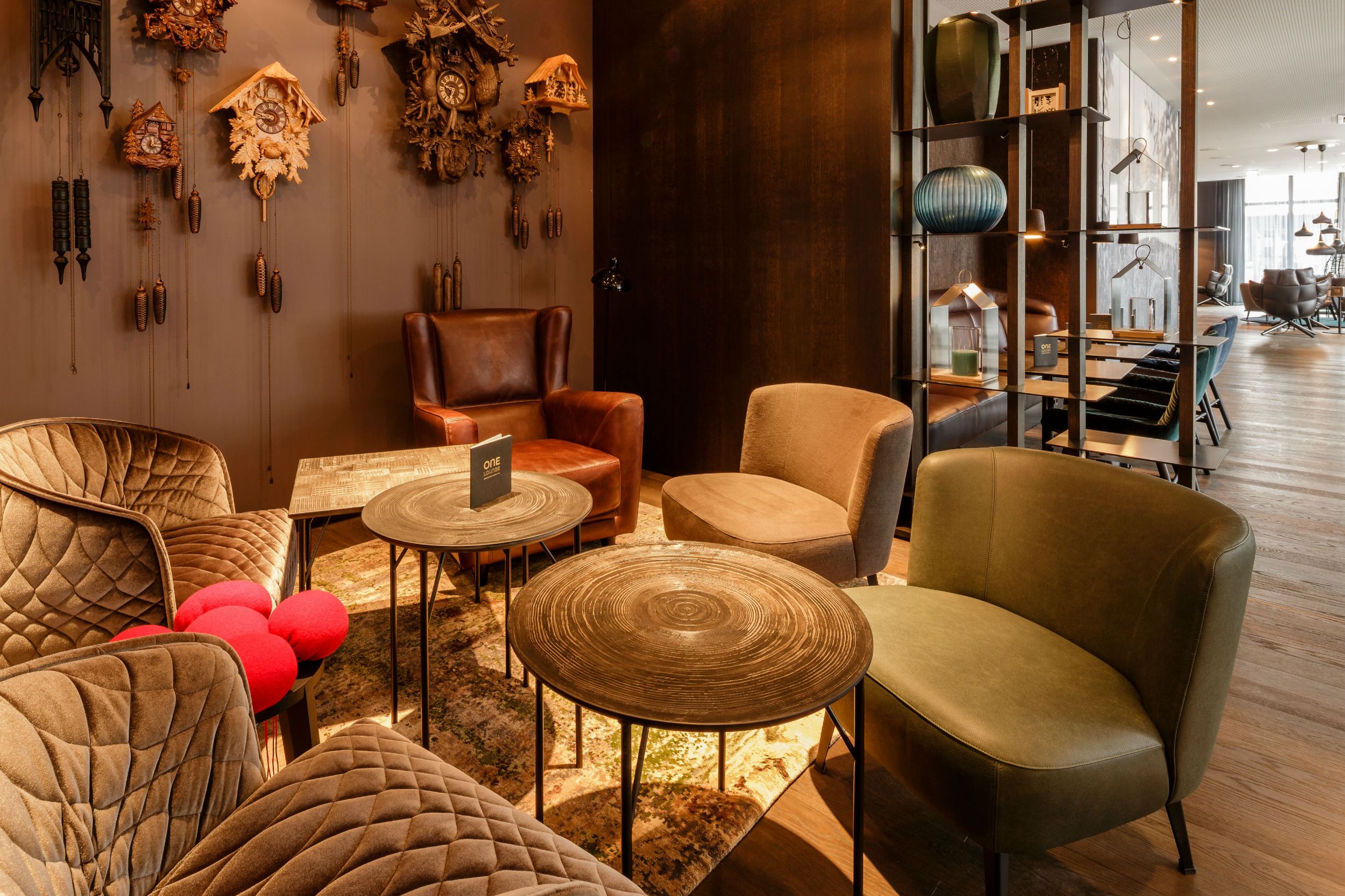 Hotel Freiburg Motel One Lounge mit Sitzbereich und Kuckucksuhren an der Wand
