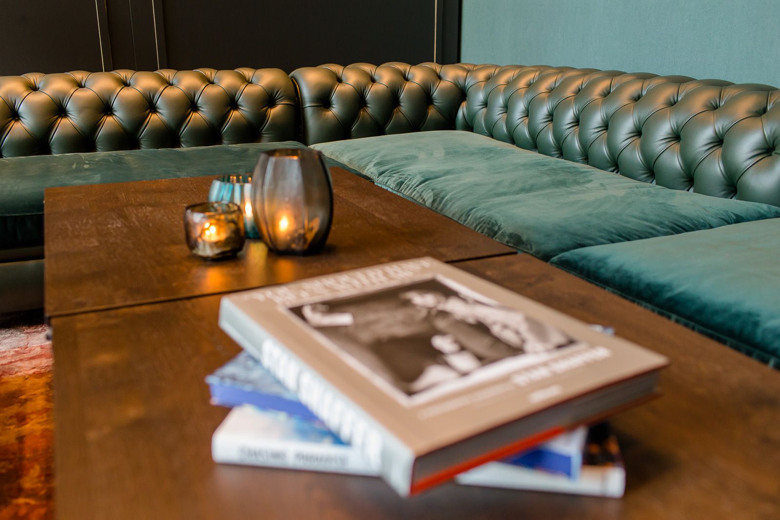 Hotel Glasgow Motel One Nahaufnahme auf einen Tisch mit Büchern und drei Kerzen vor einem großen Ecksofa
