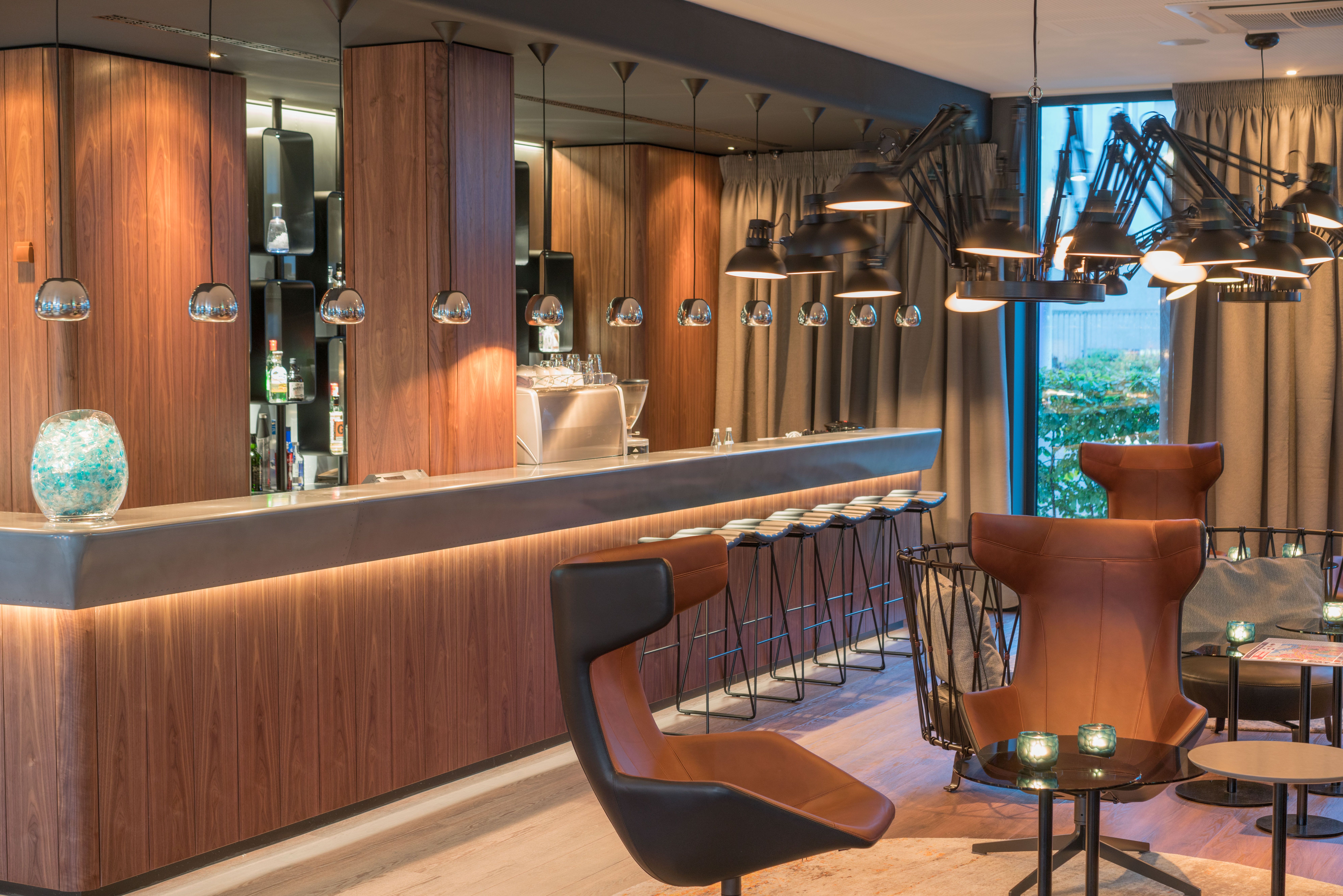 Hotel Hamburg Airport Motel One lange Bar mit Barhockern sowie Sitzgelegenheiten im Vordergrund