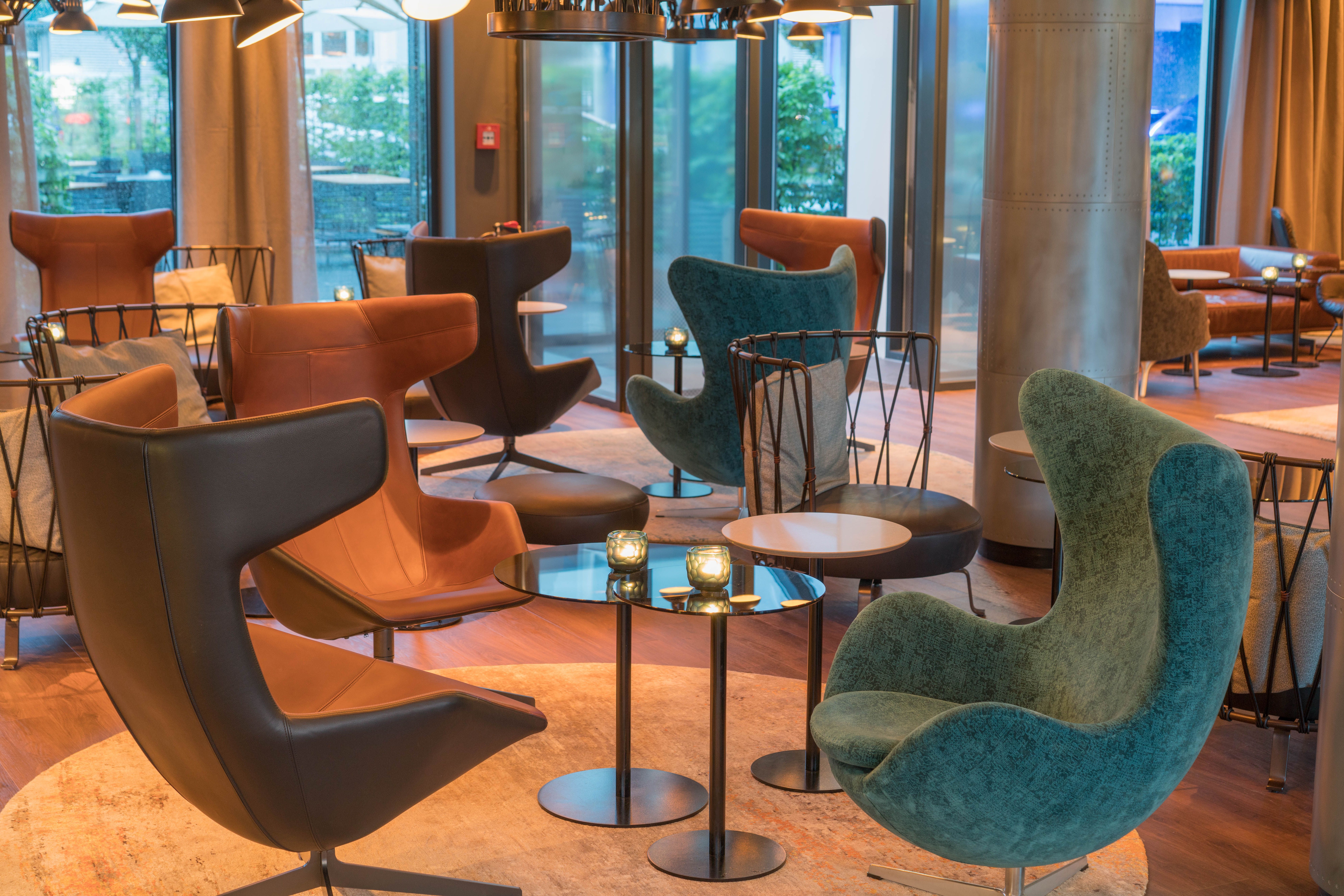 Hotel Hamburg Airport Motel One helle Lounge mit mehreren Egg Chairs und Sesseln