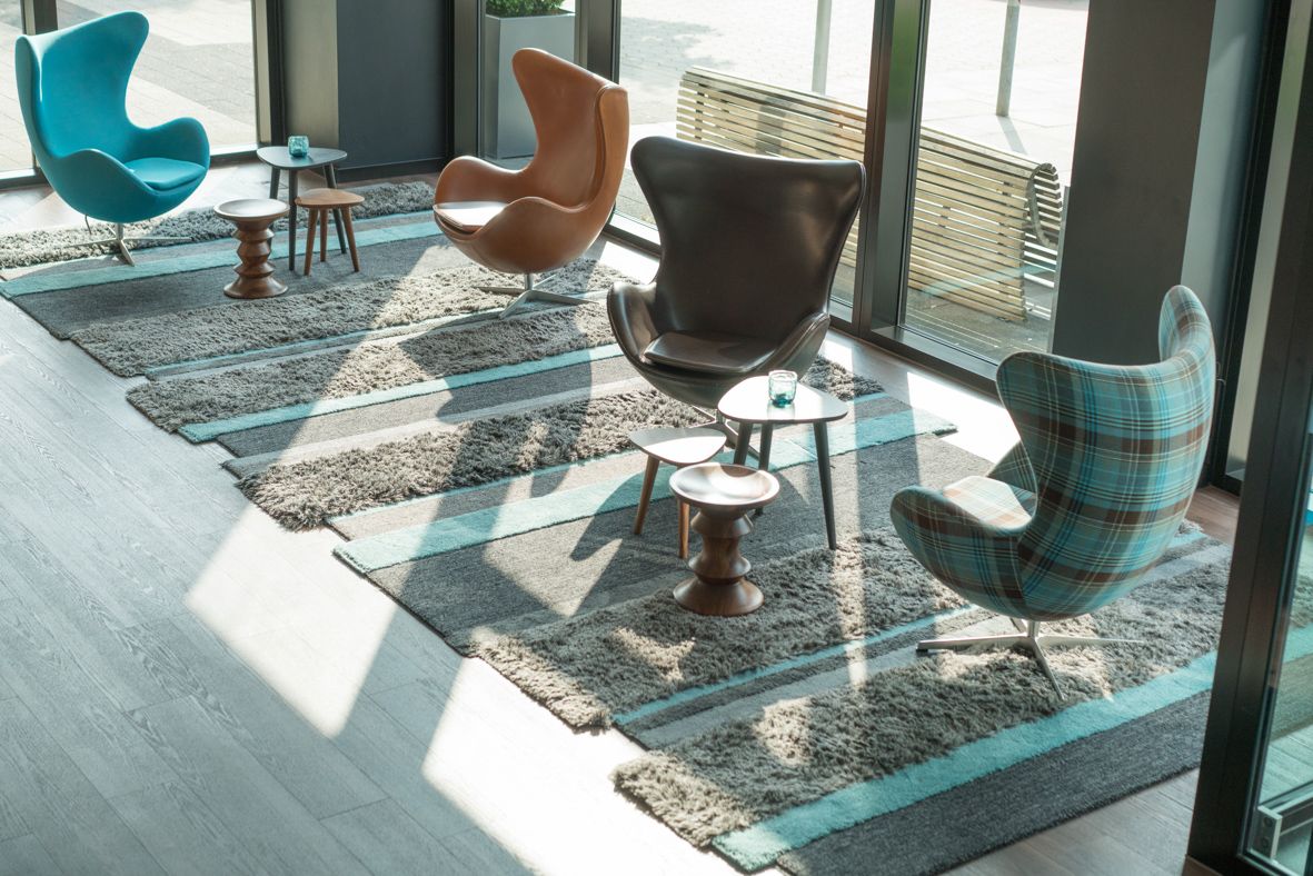 hotel Hamburg Alster Motel One bright lounge with four egg chairs and floor-to-ceiling windows with sunlight