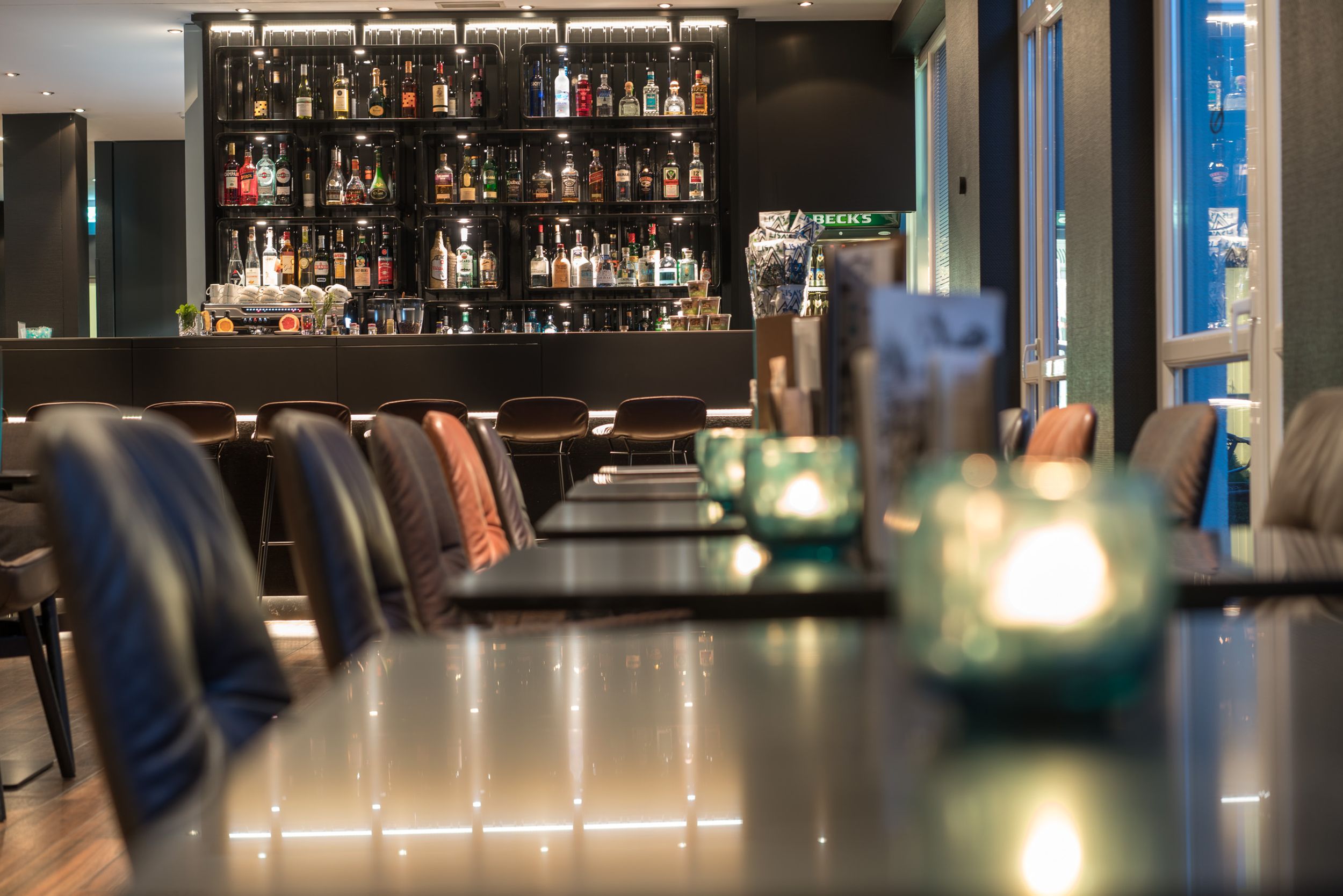 Hotel Hamburg Altona Motel One mehrere Tische und Blick auf die Bar